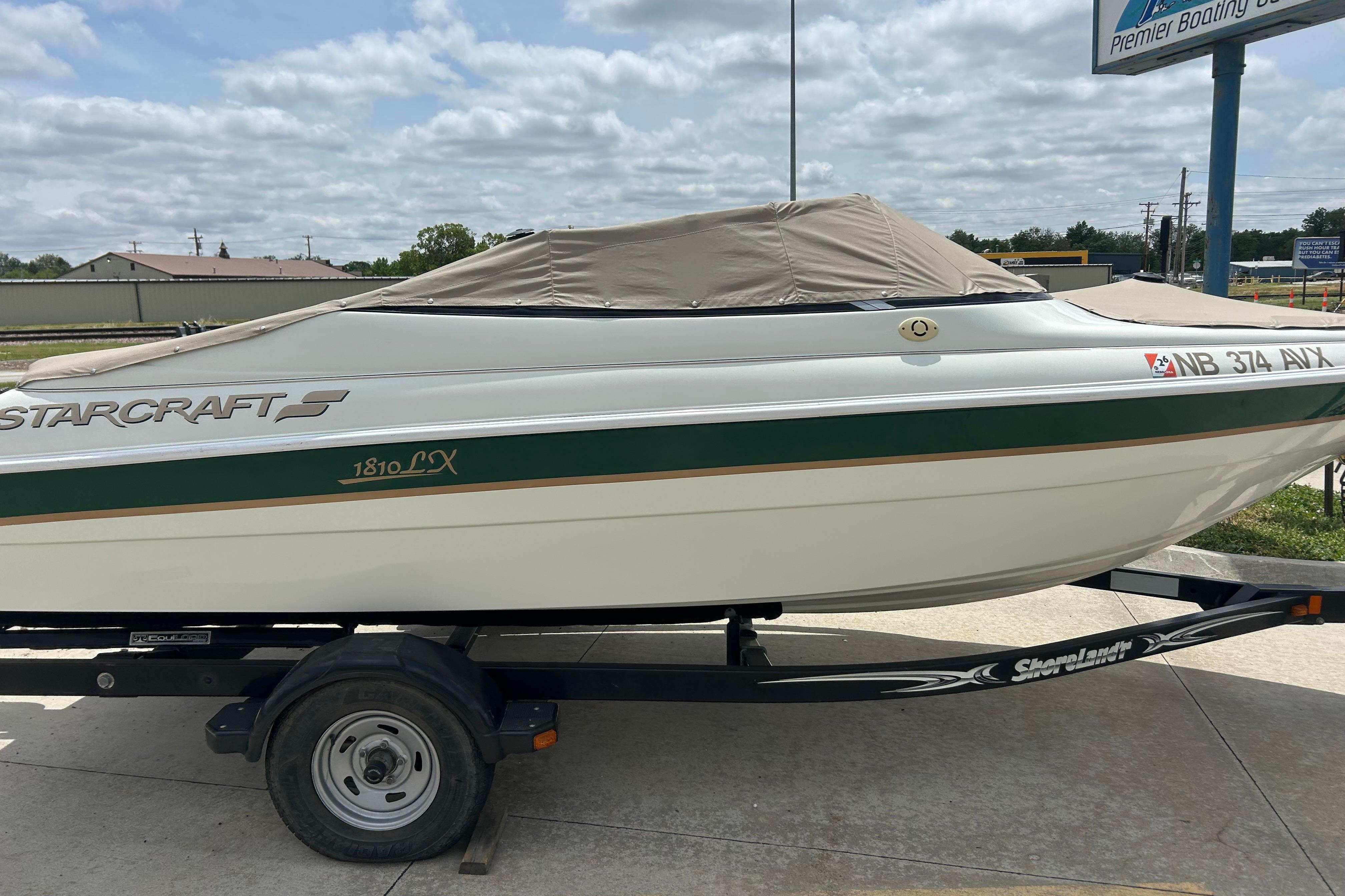 2000 Starcraft 1810 boat on trailer, covered, parked outdoors.