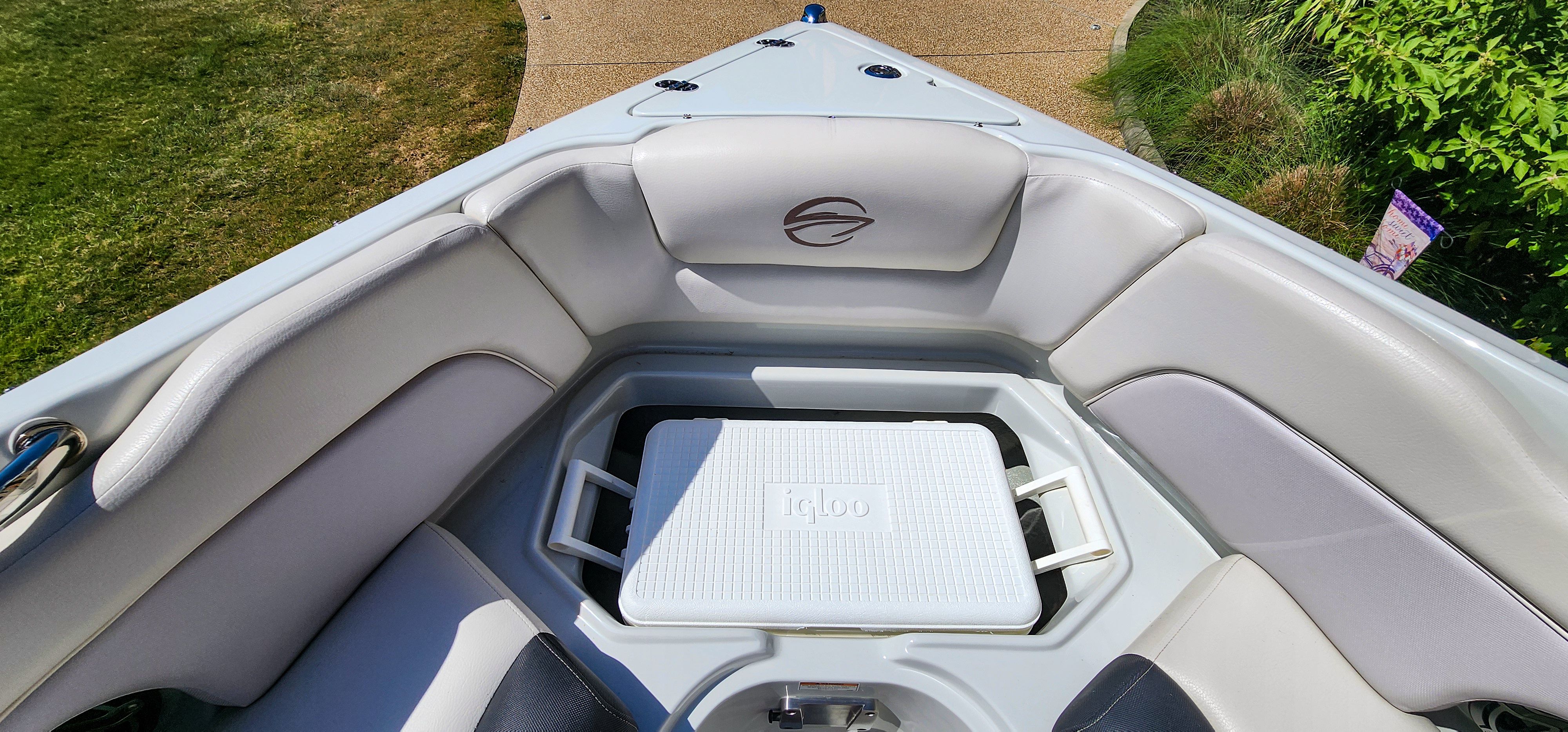 The image shows the bow of a Crownline 285SS boat with cushioned seating and a cooler.