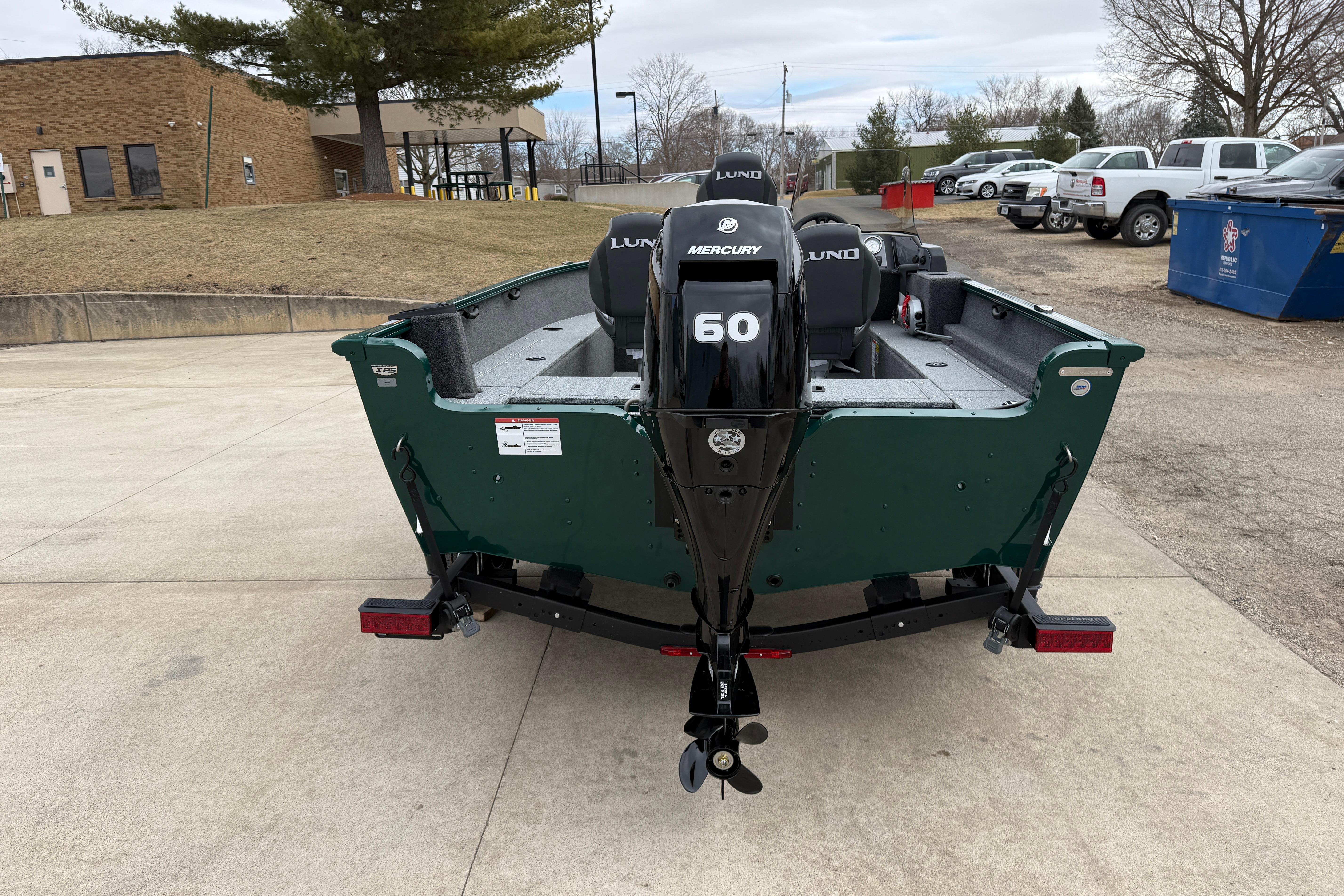 2026 Lund 1650 Rebel XL SS boat with Mercury 60 engine, parked outdoors.