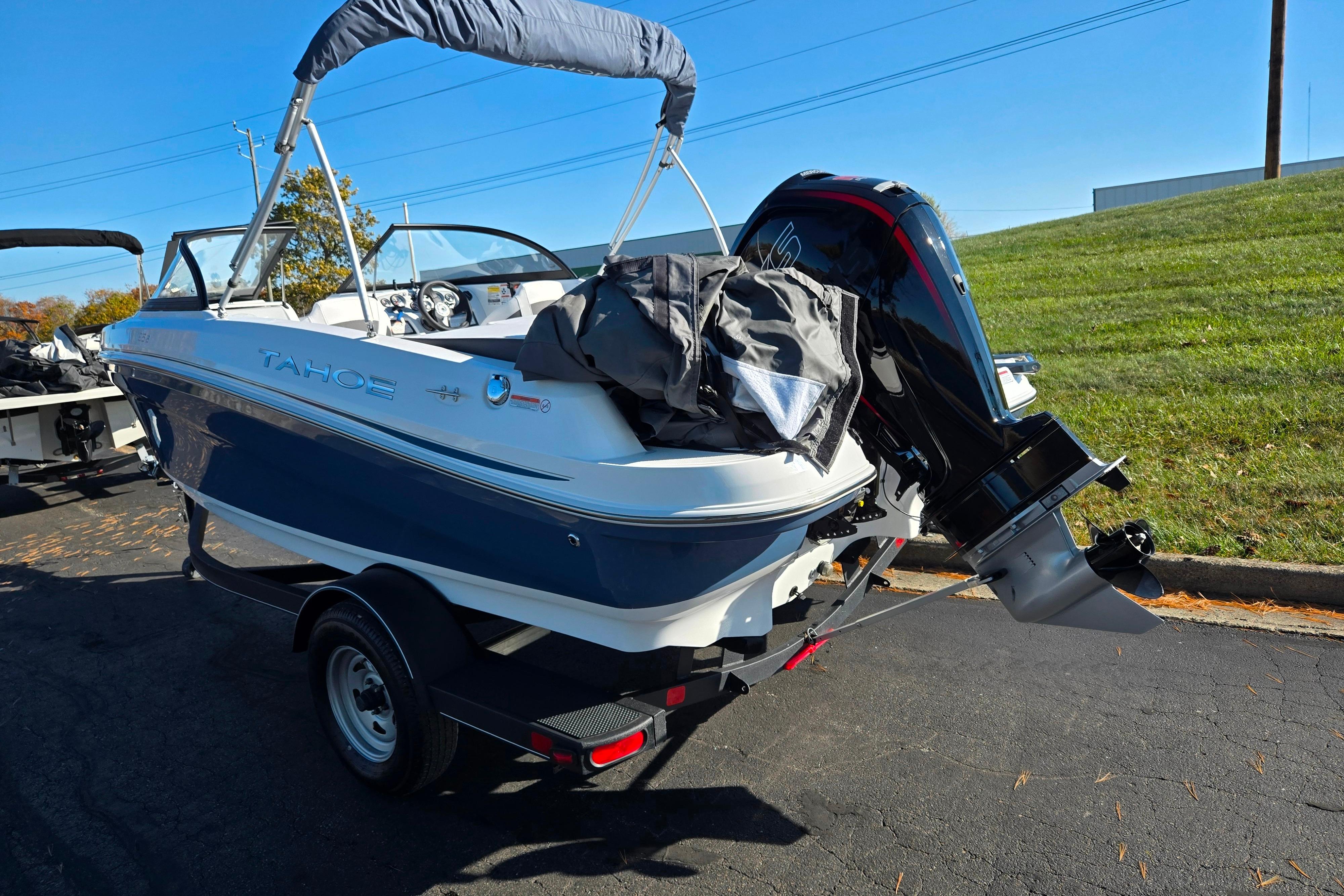 2023 Tahoe 185 S boat on trailer, parked outdoors, with outboard motor.