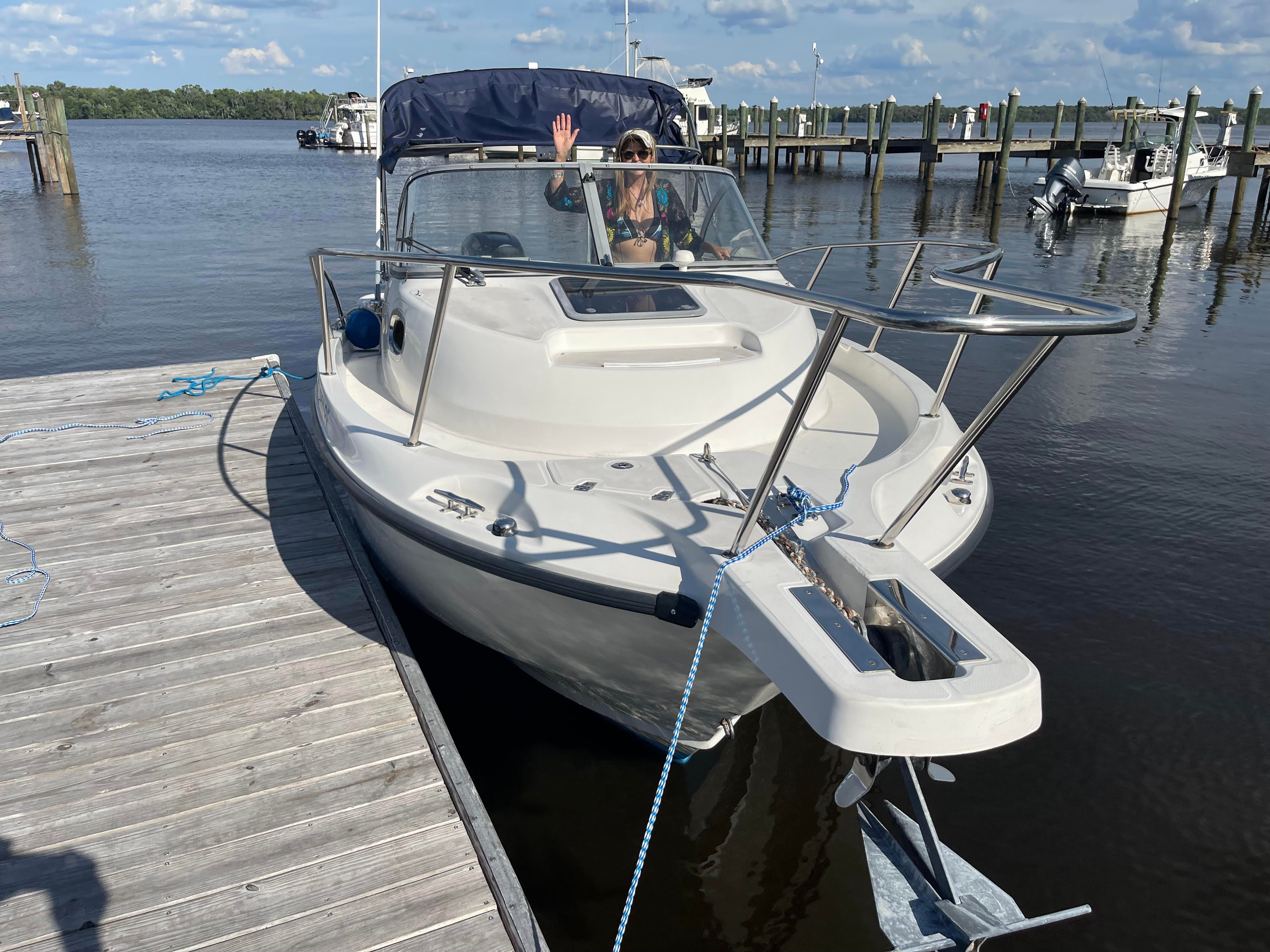 2010 Boston Whaler 235 Conquest docked with person on board.