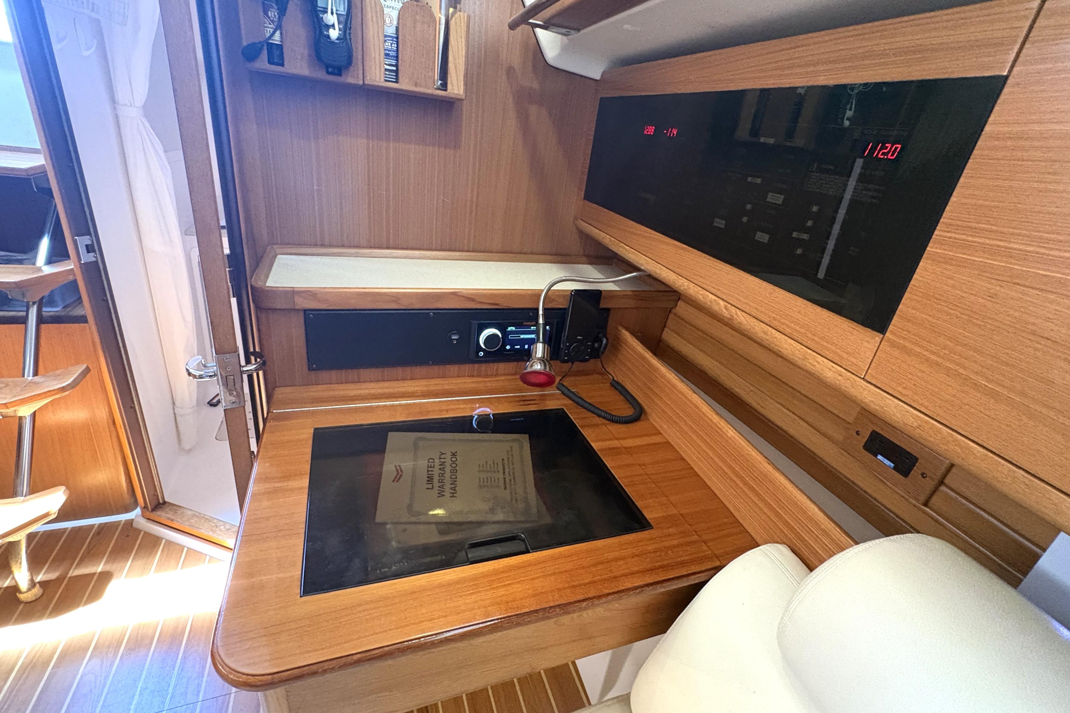 Interior of a 2011 Catalina 355 yacht featuring a navigation station with wood finish.
