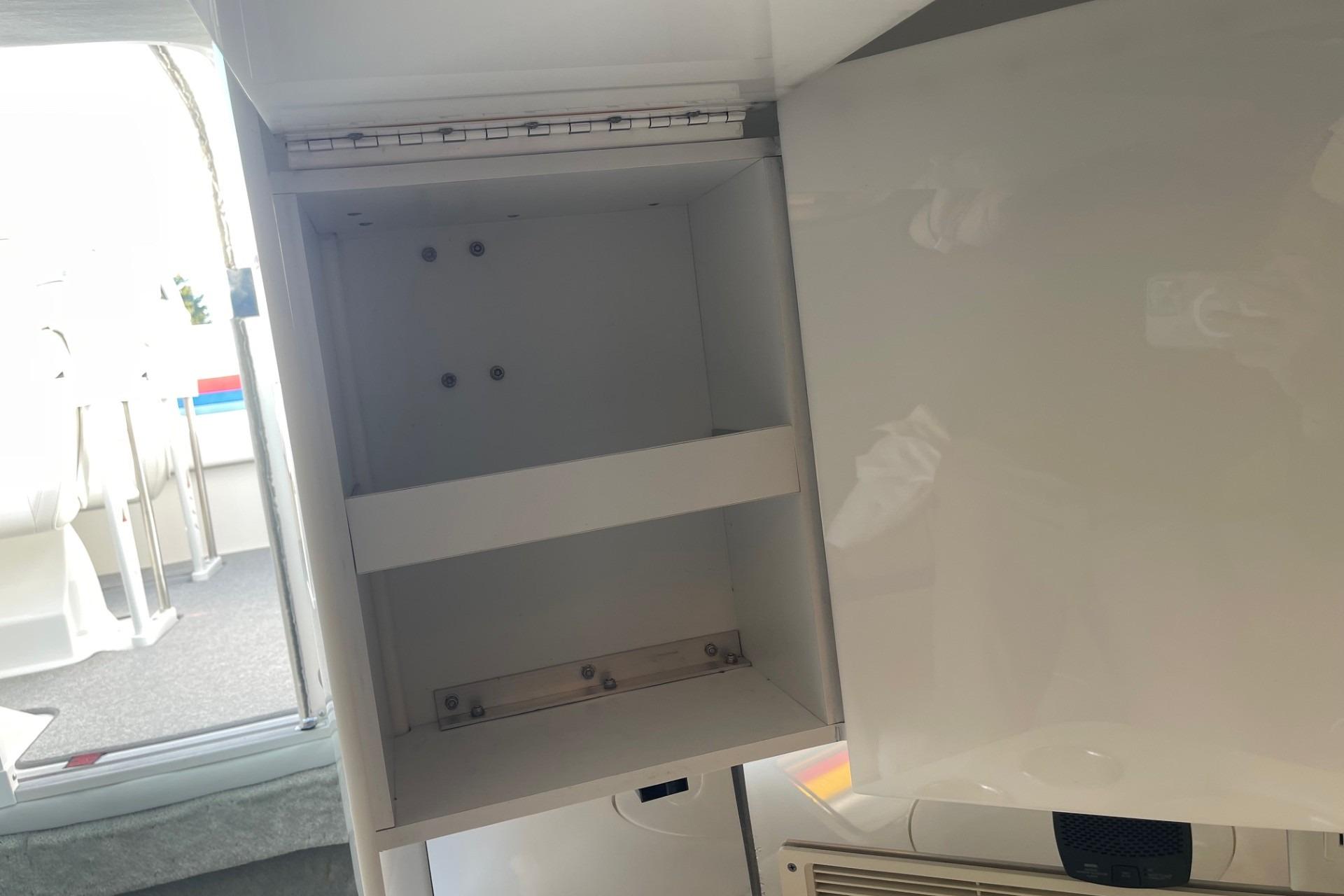 Open storage compartment inside a 2004 Formula 382 FASTech boat, showcasing interior shelving.