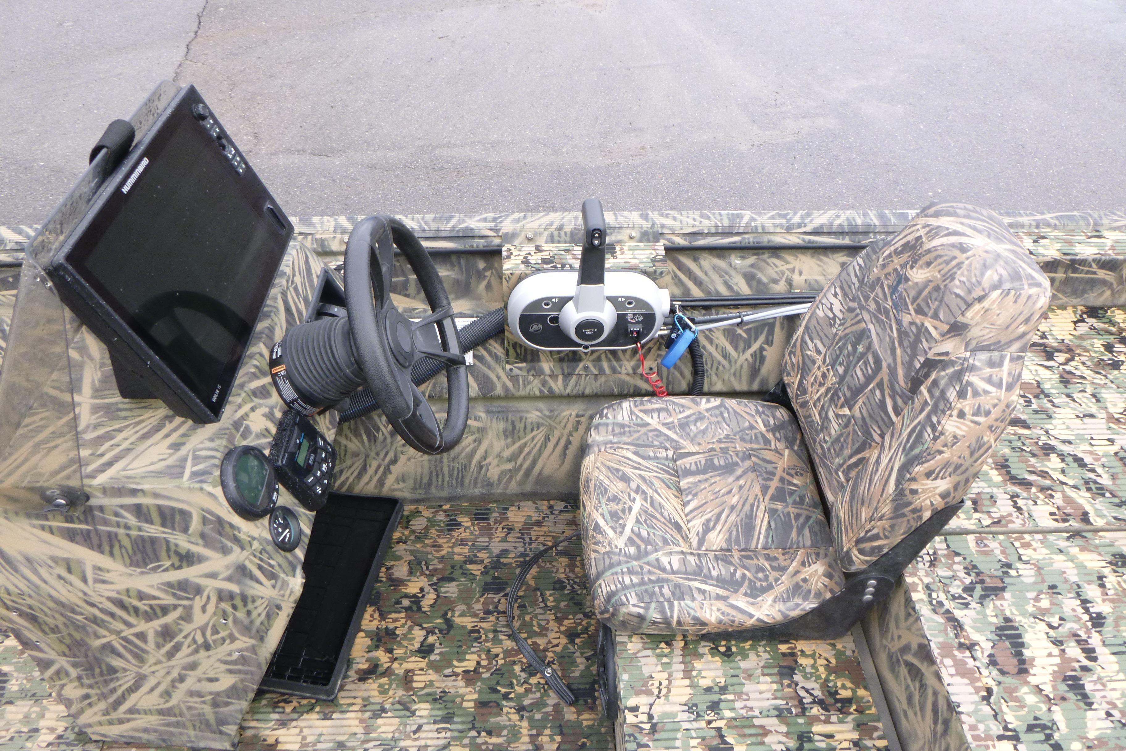 2024 Lowe Roughneck 2070 boat interior with camouflage seating and steering console.