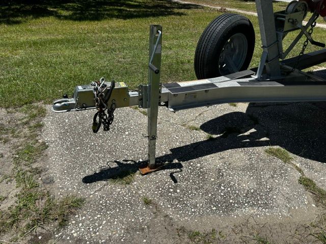 A boat trailer is parked on a paved outdoor area.