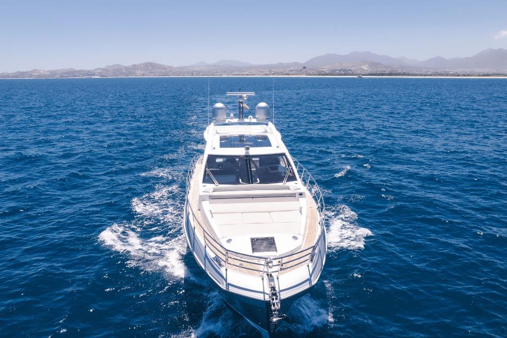 Azimut 60 yacht cruising on open sea, 2020 model, with scenic coastal backdrop.