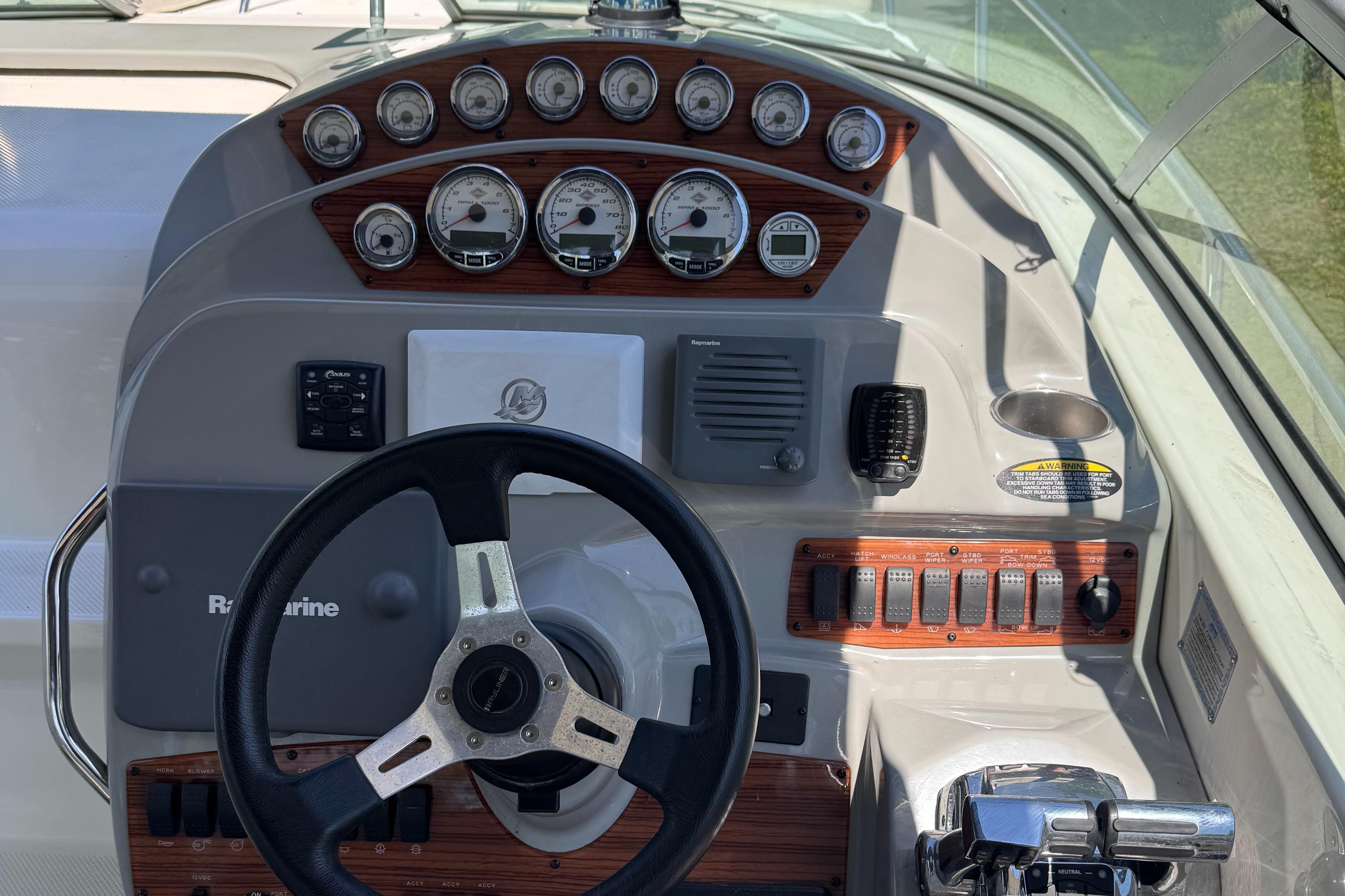 Dashboard of a 2009 Bayliner 300 boat with steering wheel and control panel.