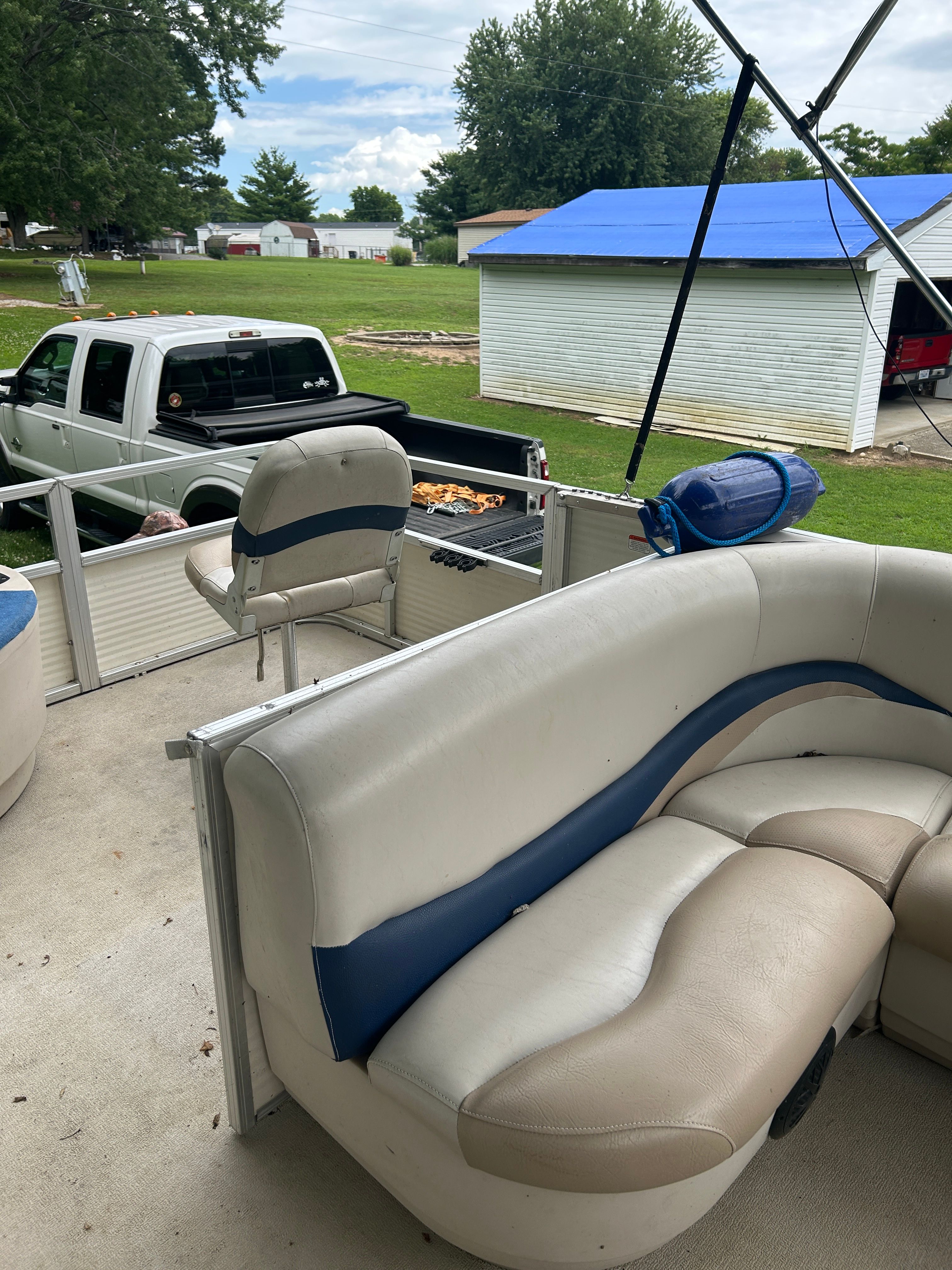 Interior view of a 2008 Sun Tracker Fishin' Barge 21' with white and blue seating.