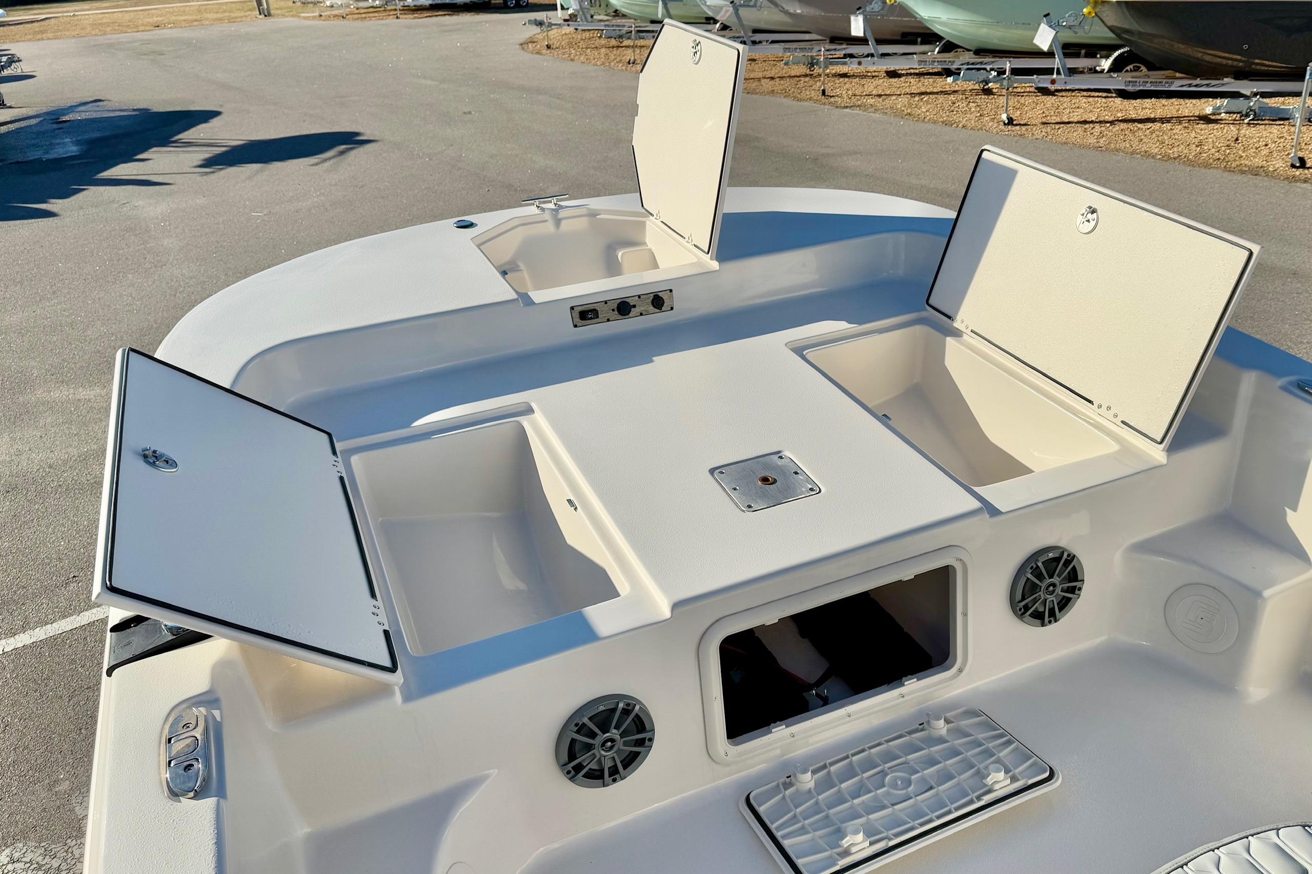 2025 Carolina Skiff 21 LS boat with open storage compartments and speakers.