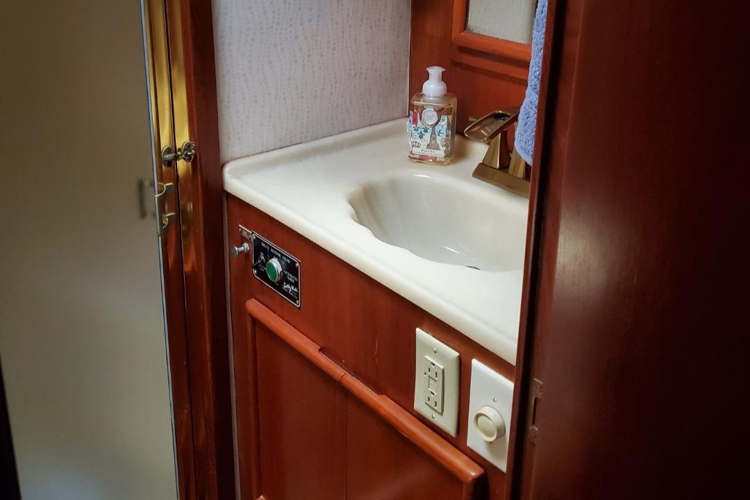 1988 Post 46 Sportfish bathroom sink with wooden cabinetry and soap dispenser.