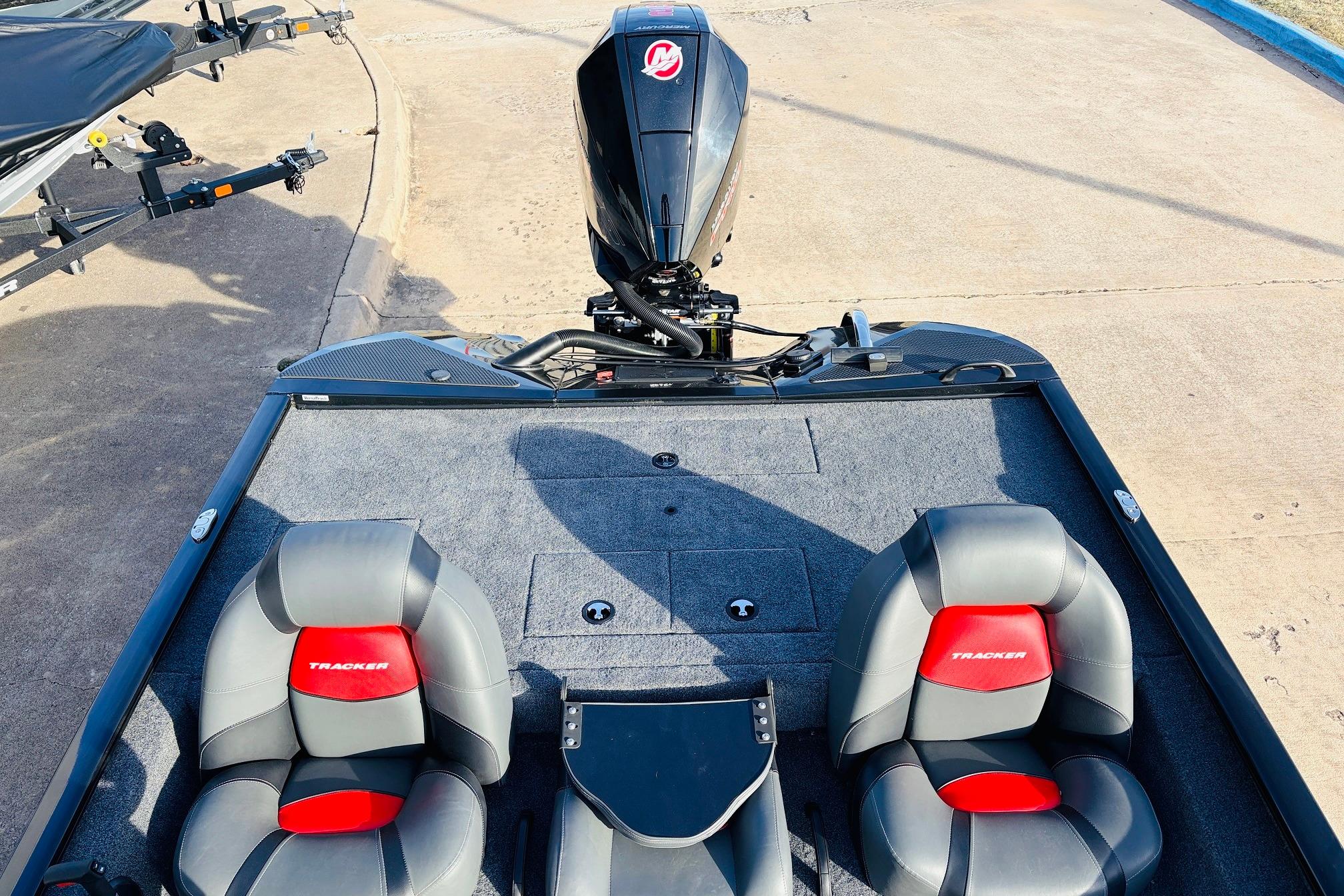 2025 Tracker Savage 215 boat interior with dual seats and motor, parked on concrete.
