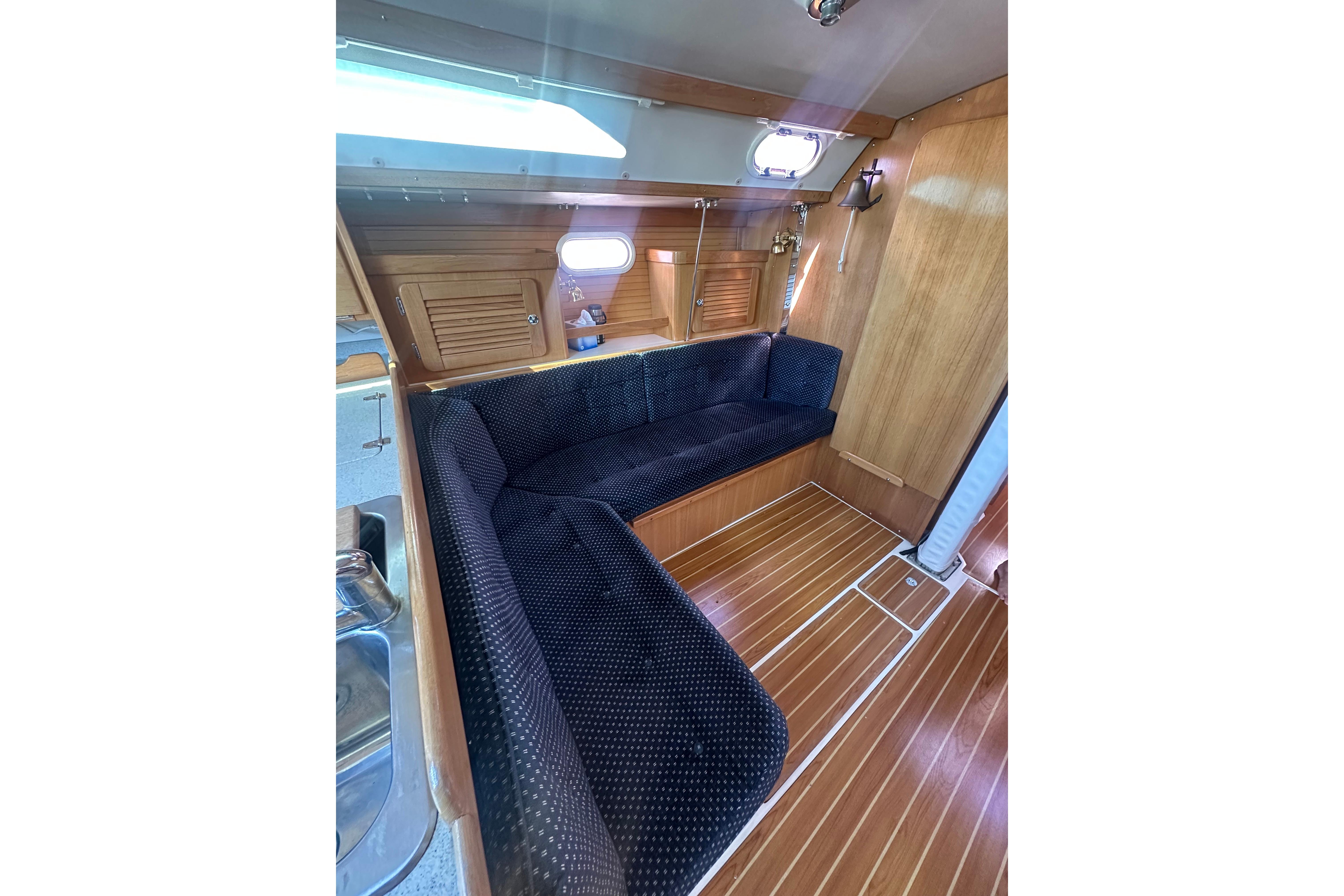 Interior of 2005 Catalina 36 MkII sailboat with wooden flooring and cozy seating area.