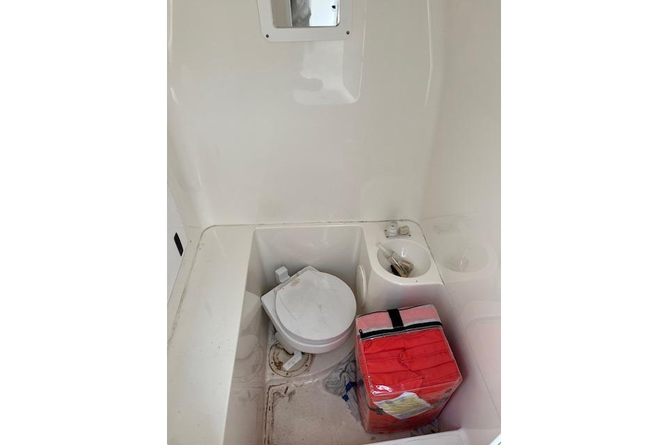2001 Fountain 38 Center Console boat interior with toilet and storage area.