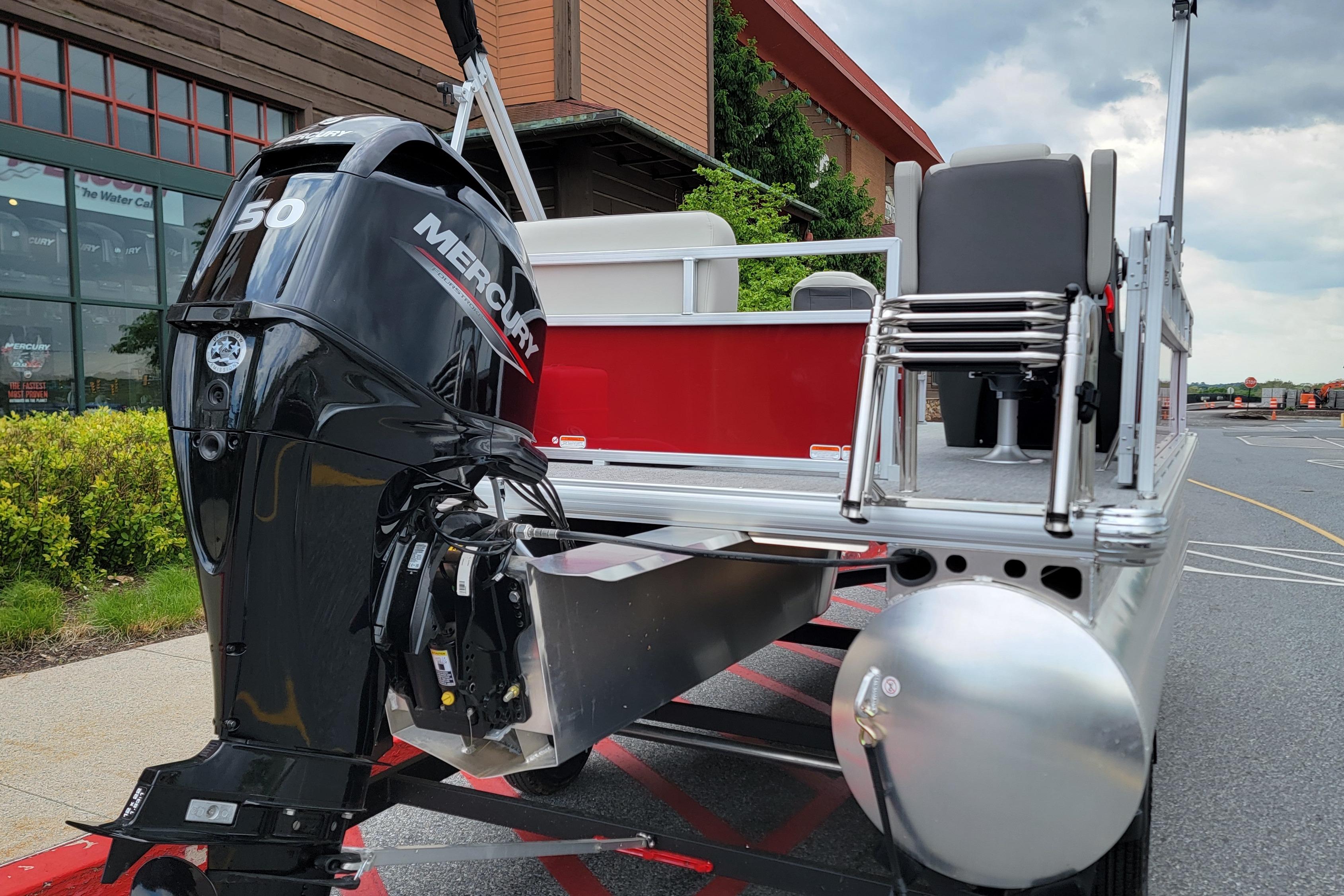 2026 Sun Tracker Bass Buggy 16 XL Select pontoon boat with Mercury 50 engine, parked outdoors.