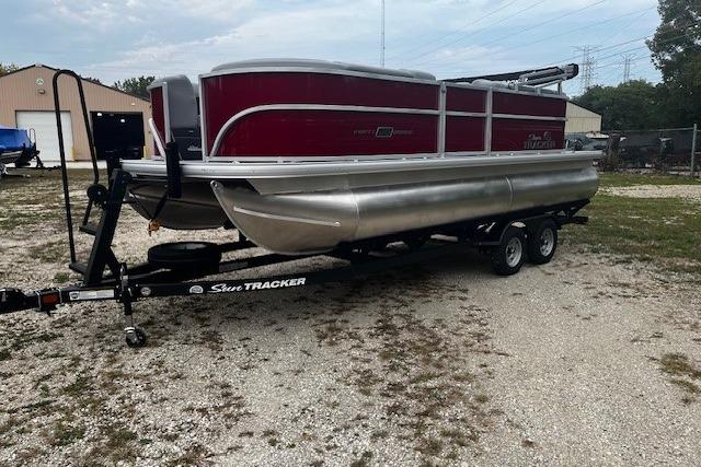2026 Sun Tracker Party Barge 20 DLX pontoon boat on trailer in outdoor setting.