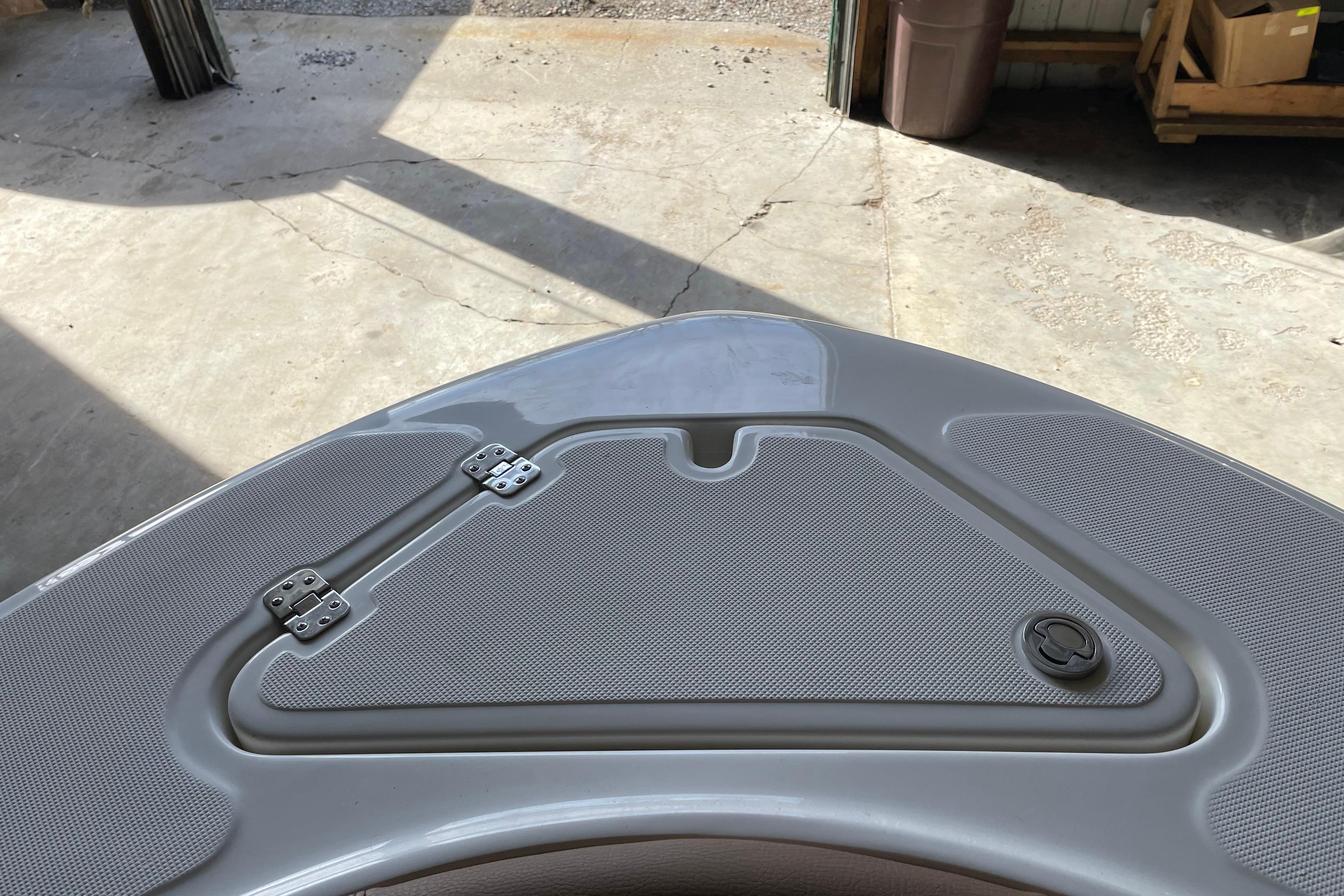 Bow of 2026 Pioneer 202 Islander boat with storage compartment and latch.