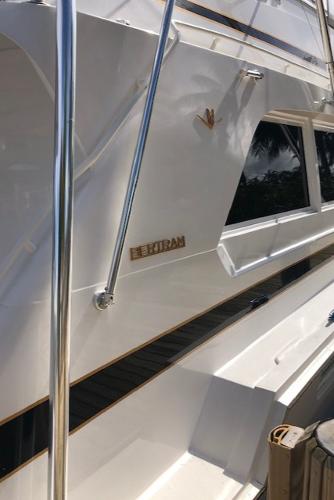1997 Bertram Convertible yacht docked, side view with logo.