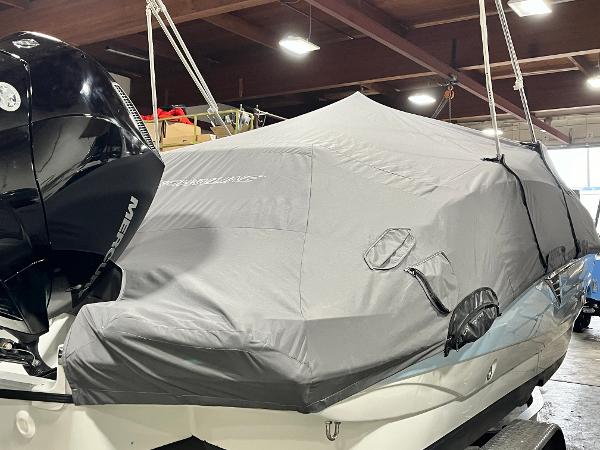 2023 Crownline Eclipse E235 XS boat covered in a protective tarp indoors.
