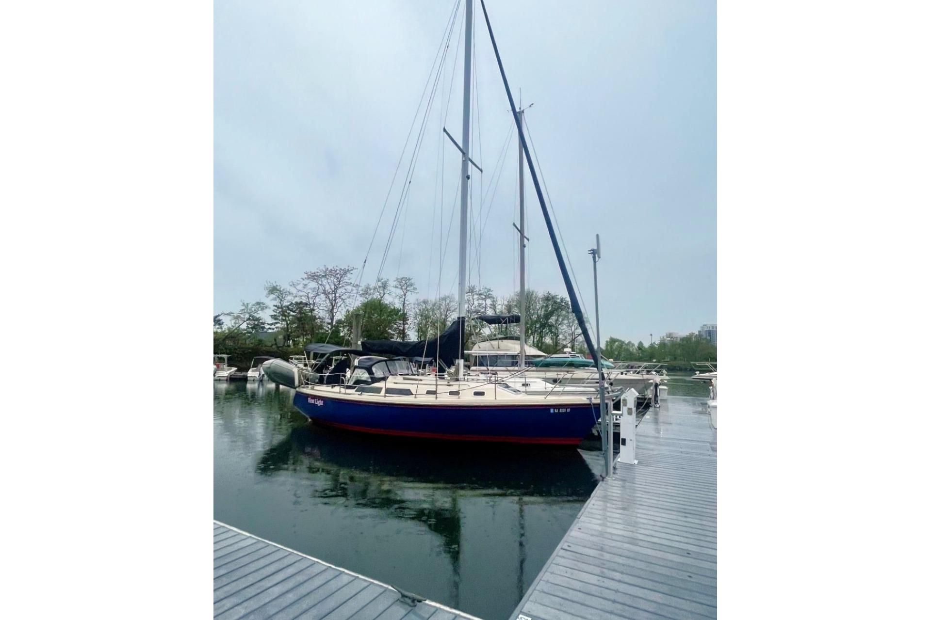 Sailboat docked at marina, 1992 Catalina 34 model, overcast sky.