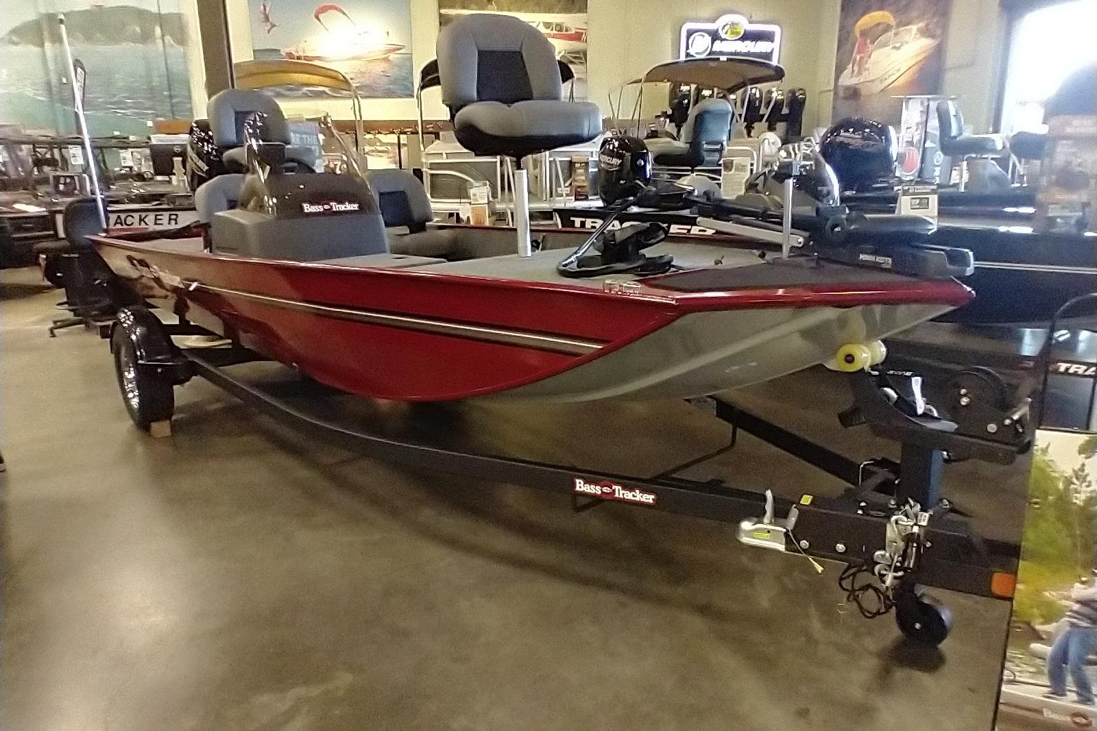 2026 Tracker Bass Tracker Classic XL boat displayed in showroom, featuring sleek red design.