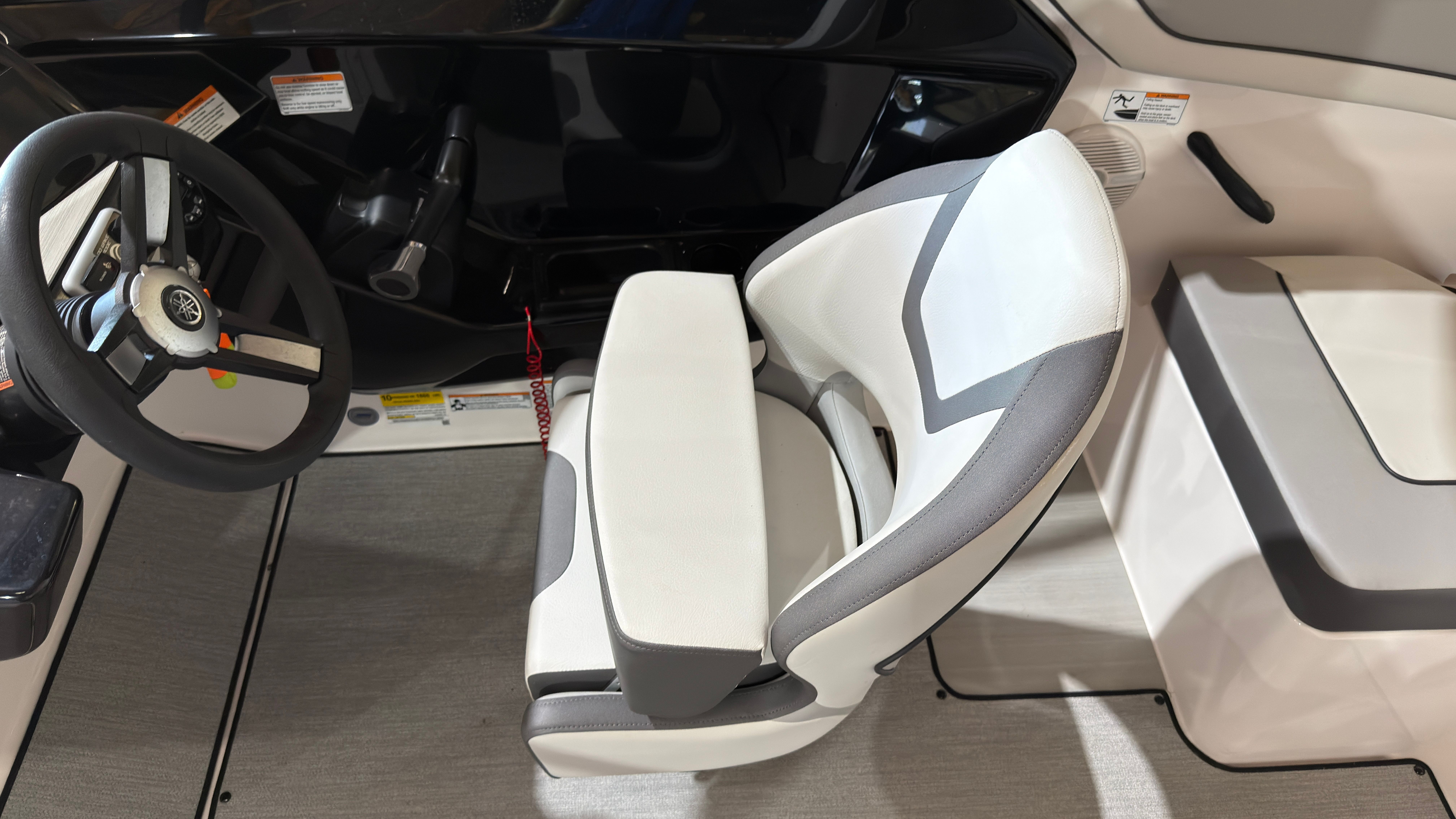 Interior of 2024 Yamaha Boats AR220 with steering wheel and seat.