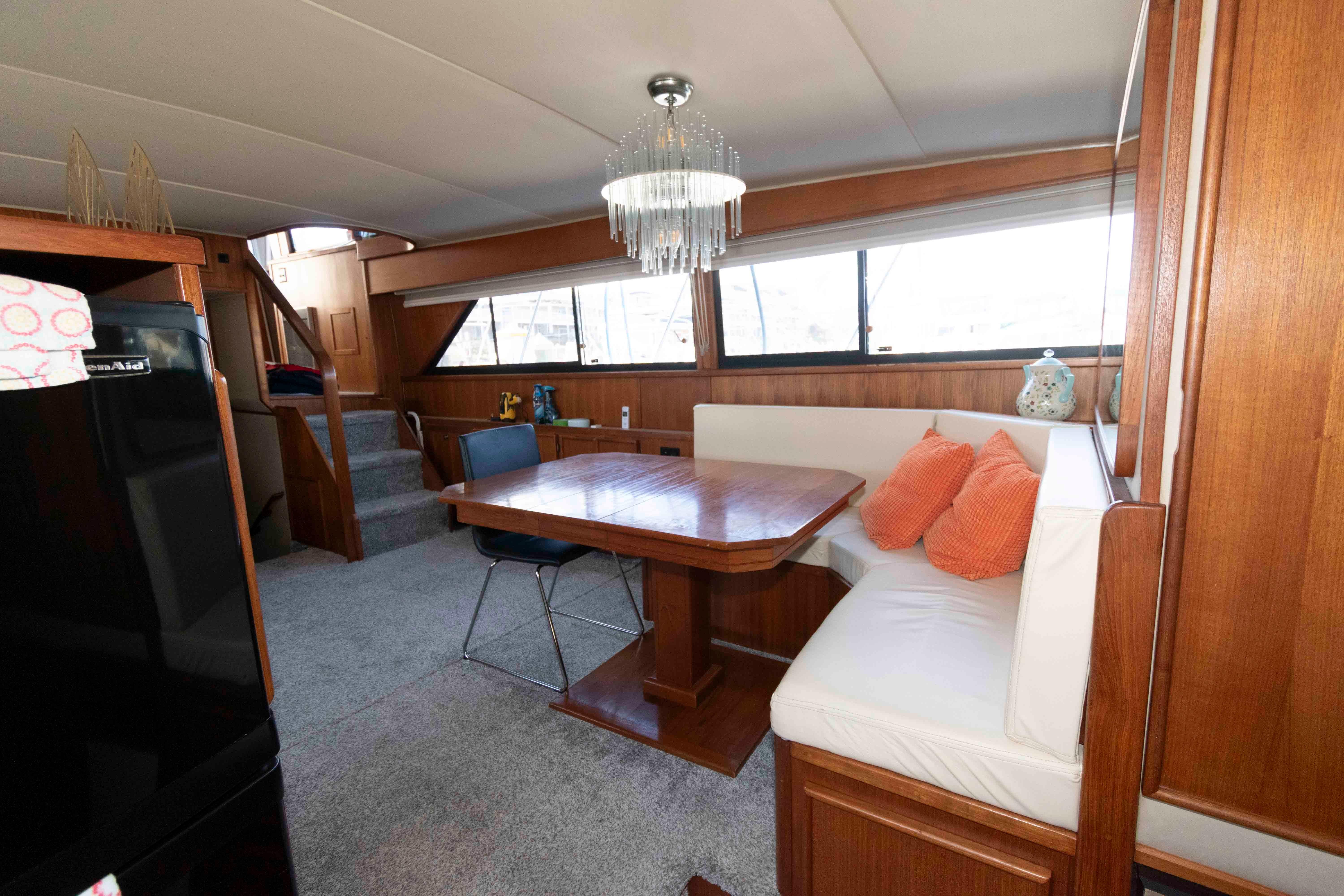 Interior of 1988 Chris-Craft 46 Constellation yacht with dining area and wooden furnishings.