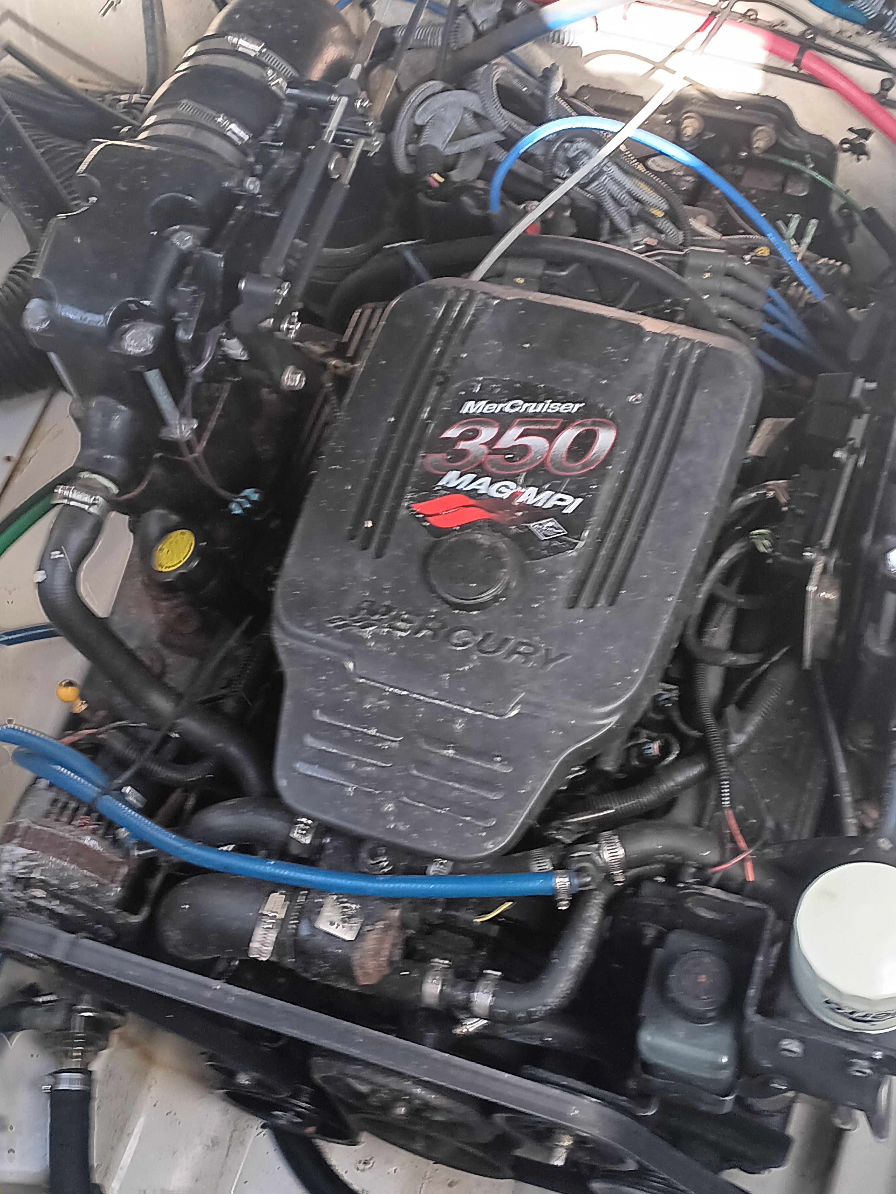 An engine compartment featuring a MerCruiser 350 MAG MPI engine, surrounded by hoses and cables.