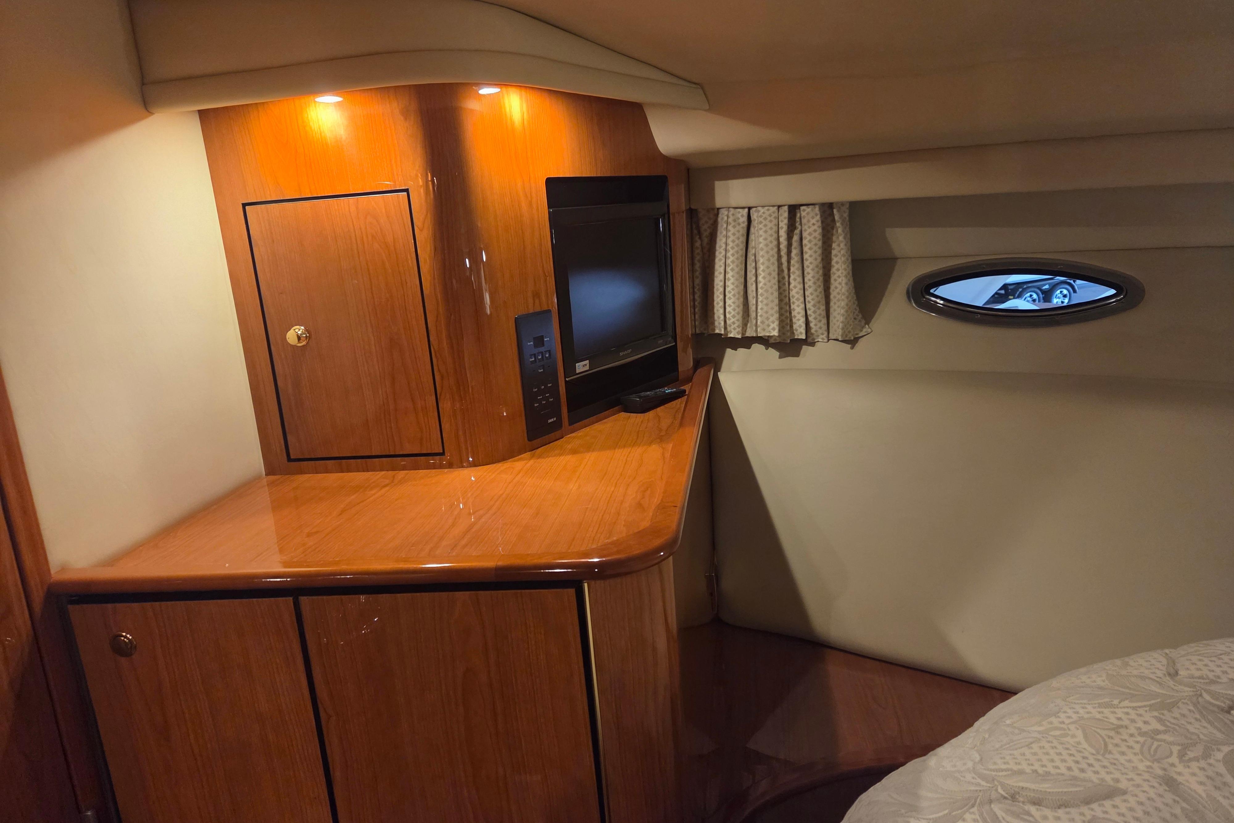 Interior of 2000 Sea Ray Sundancer 540 yacht with wood cabinetry and TV.