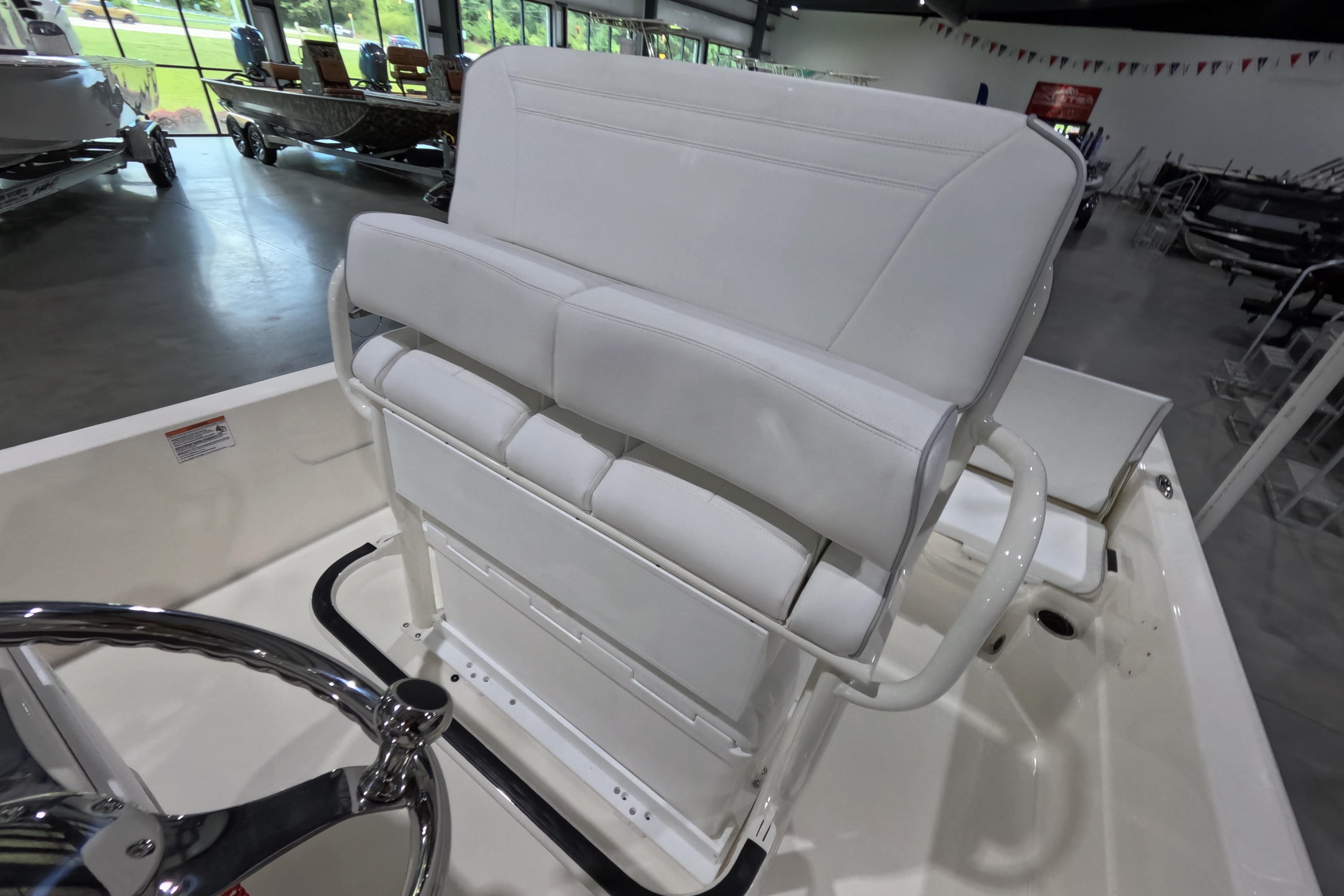 2026 Skeeter SX230 boat interior with white seating and steering wheel in showroom.