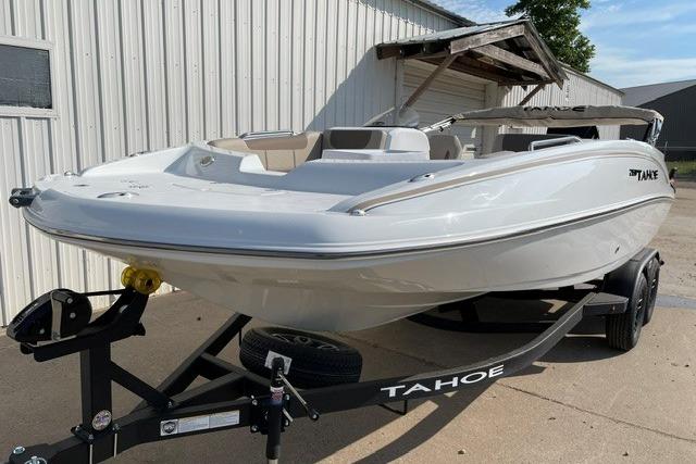 2026 Tahoe 2150 boat on trailer, parked outdoors near a metal building.