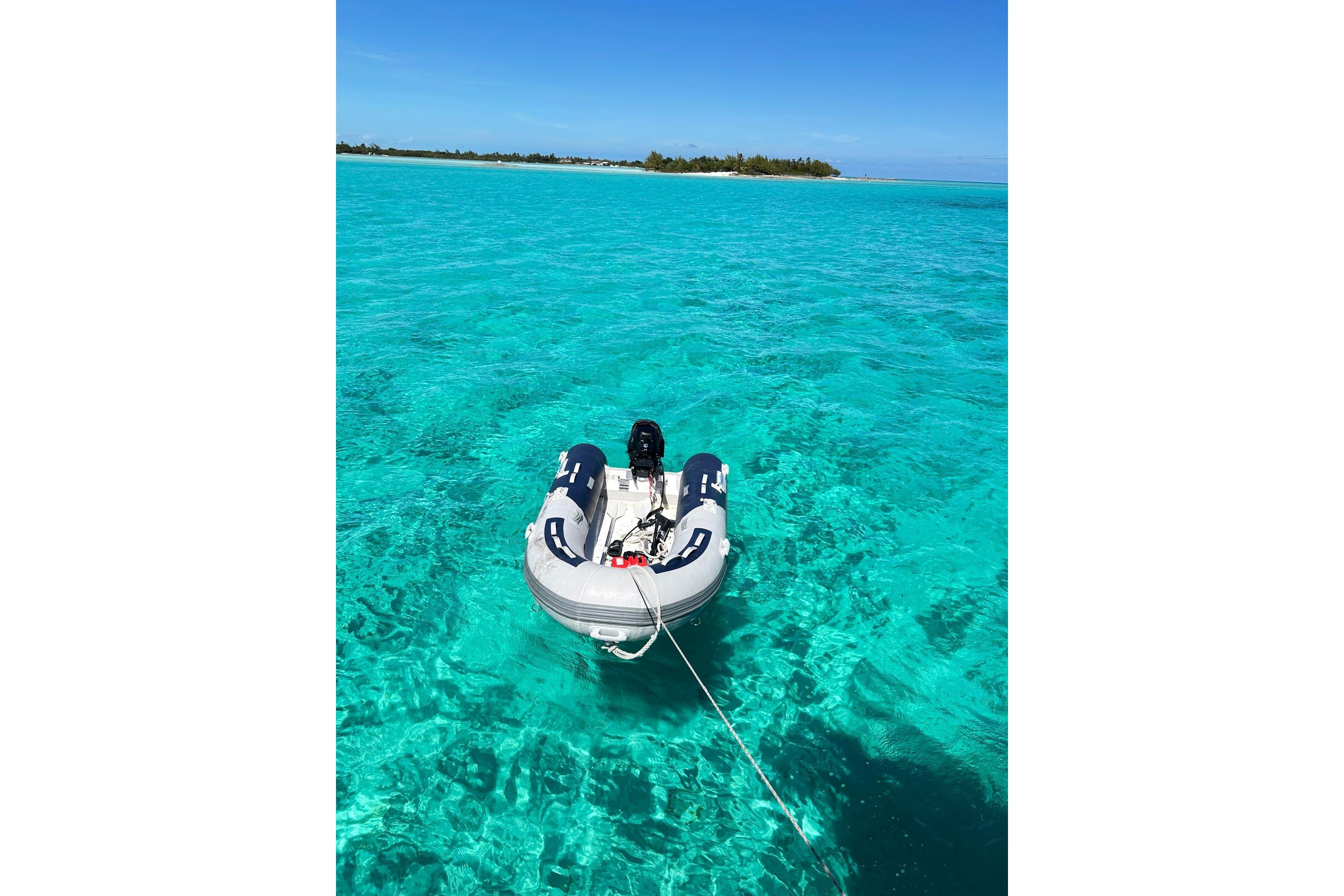 Inflatable boat on clear turquoise water near a tropical island, Gulfstar CSY 50 Pilot House 1987.