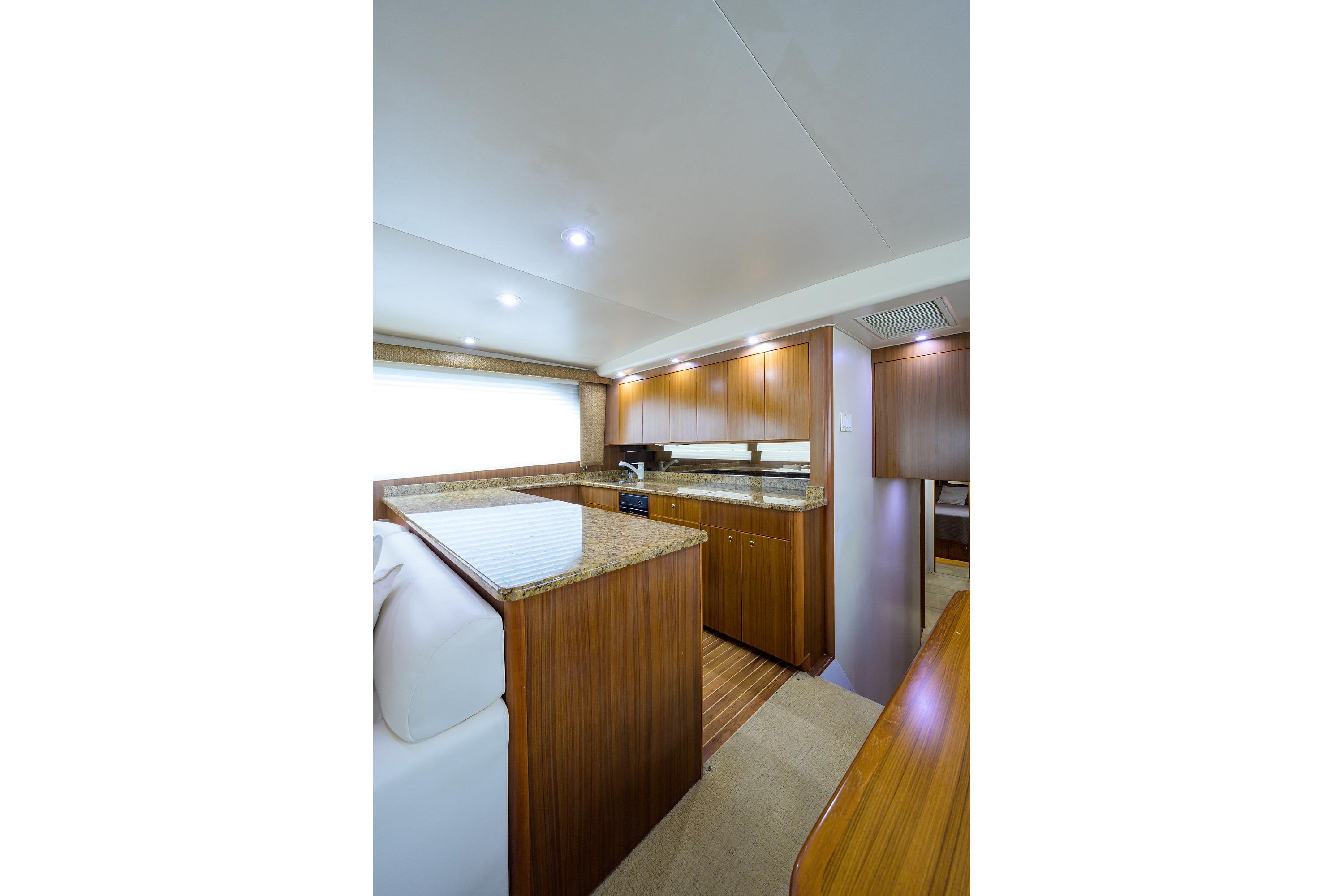 Luxurious 2005 Viking 61 yacht interior with elegant wood cabinetry and granite countertops.
