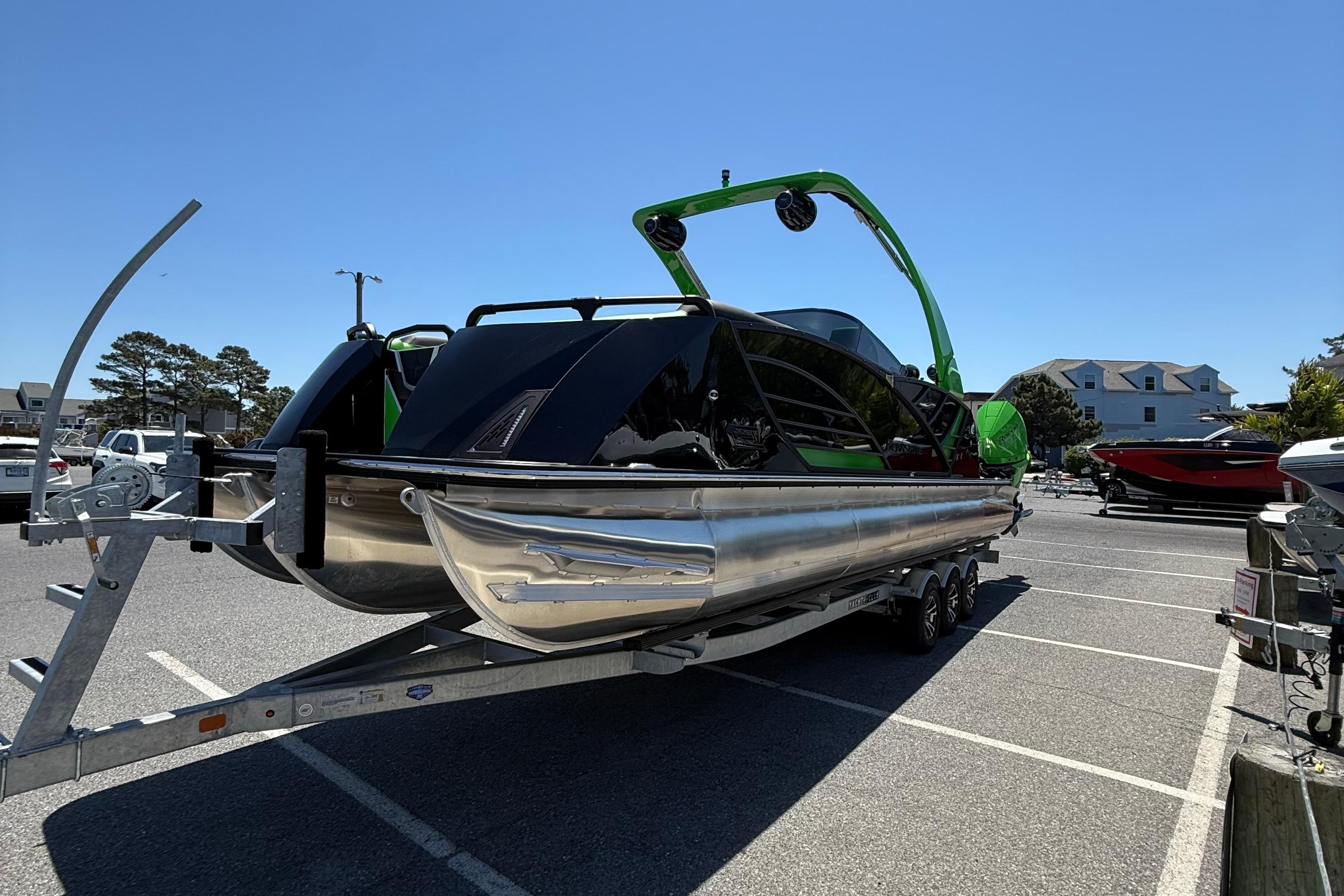 2026 Berkshire Sport SLX9 DC boat on trailer in parking lot under clear blue sky.