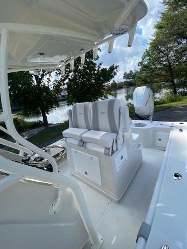 2024 Ranger 2600 Bay boat interior with seating and console, near a scenic waterfront.