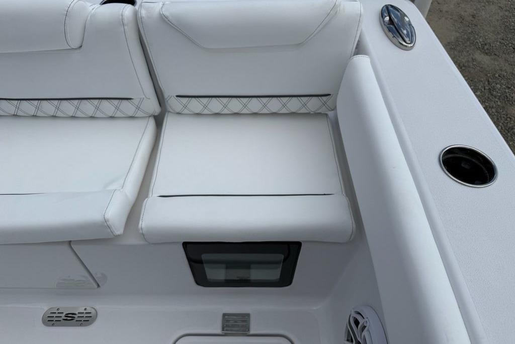 White seating on 2026 Sportsman Heritage 261 Center Console boat, featuring cup holders and speaker.