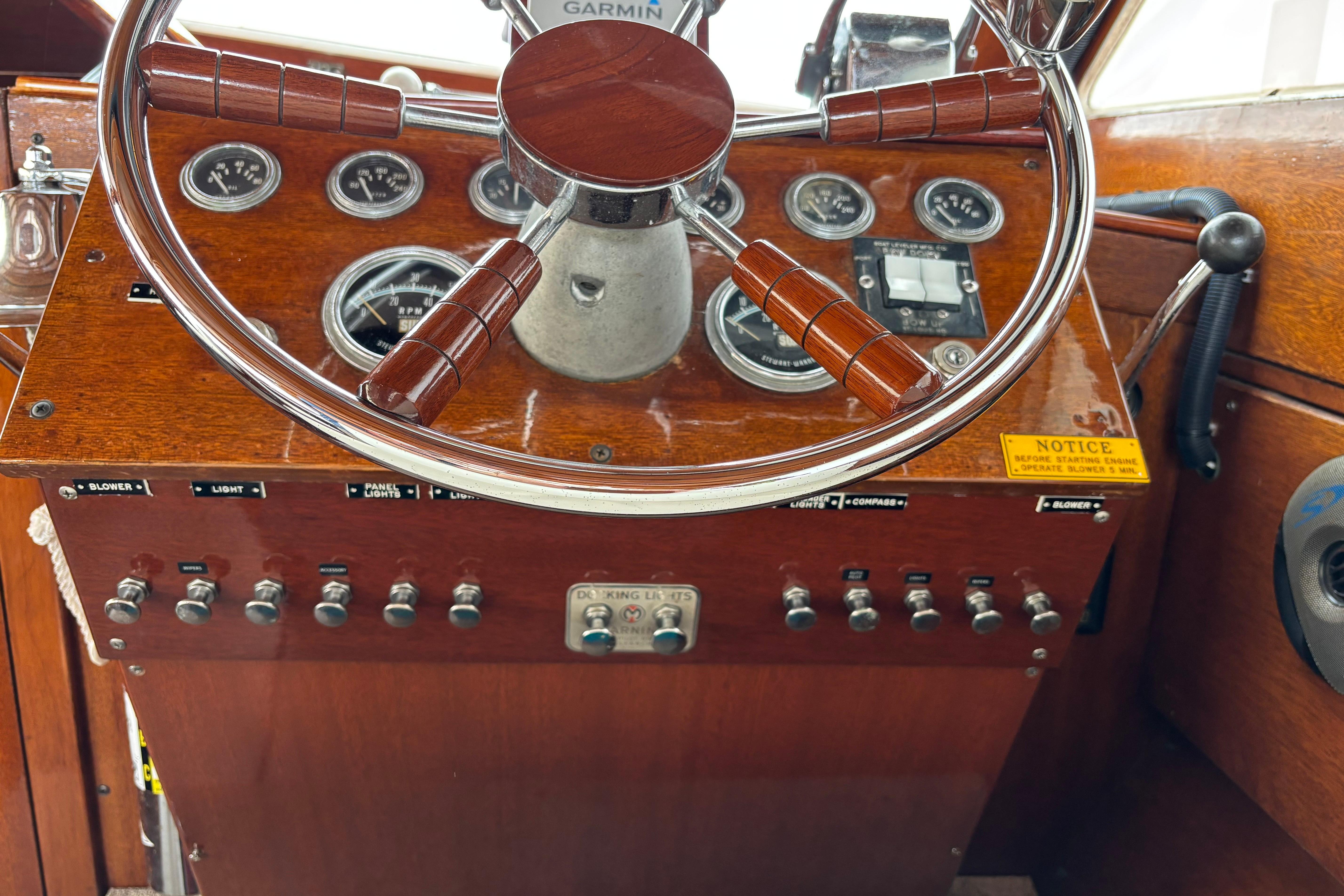1967 Lyman Islander 30 boat dashboard with wooden steering wheel and control panel.