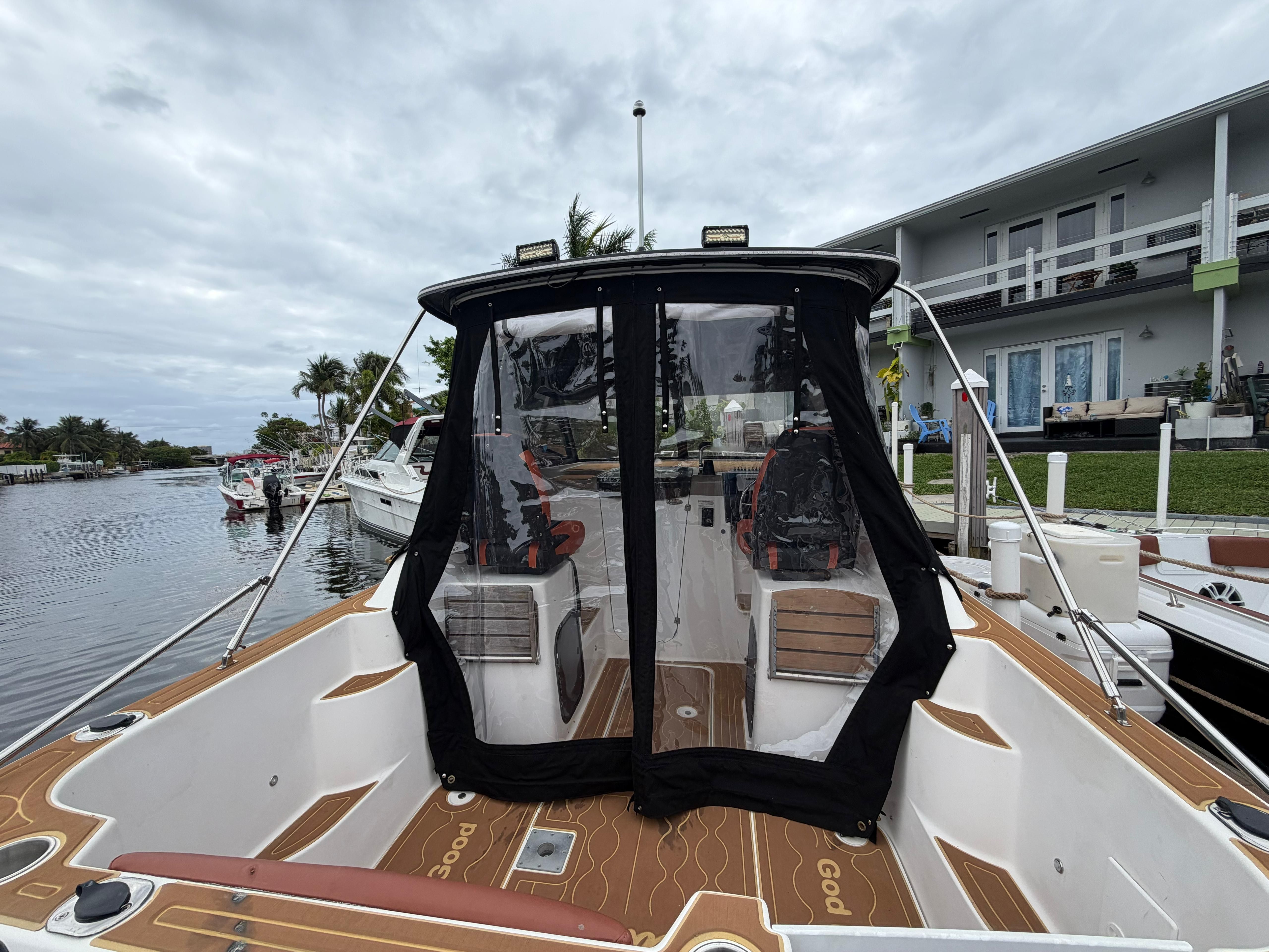 The image shows a 2001 Bayliner 2452 Ciera Classic boat docked by a waterfront home.