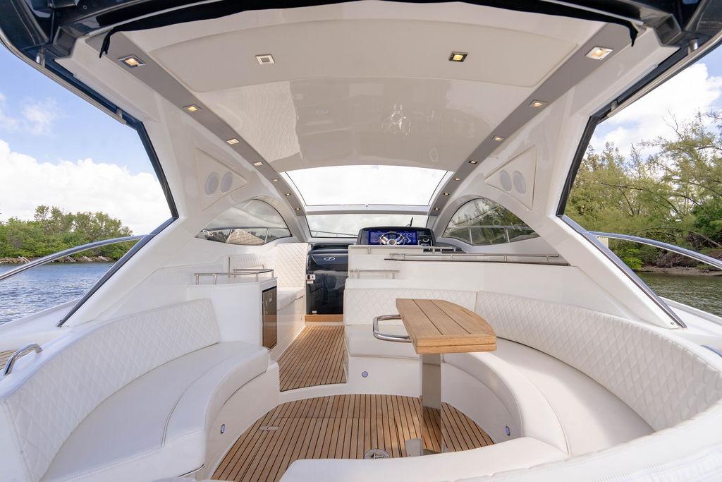 Luxurious interior of 2022 Schaefer 400 Sport yacht with elegant seating and wooden table.