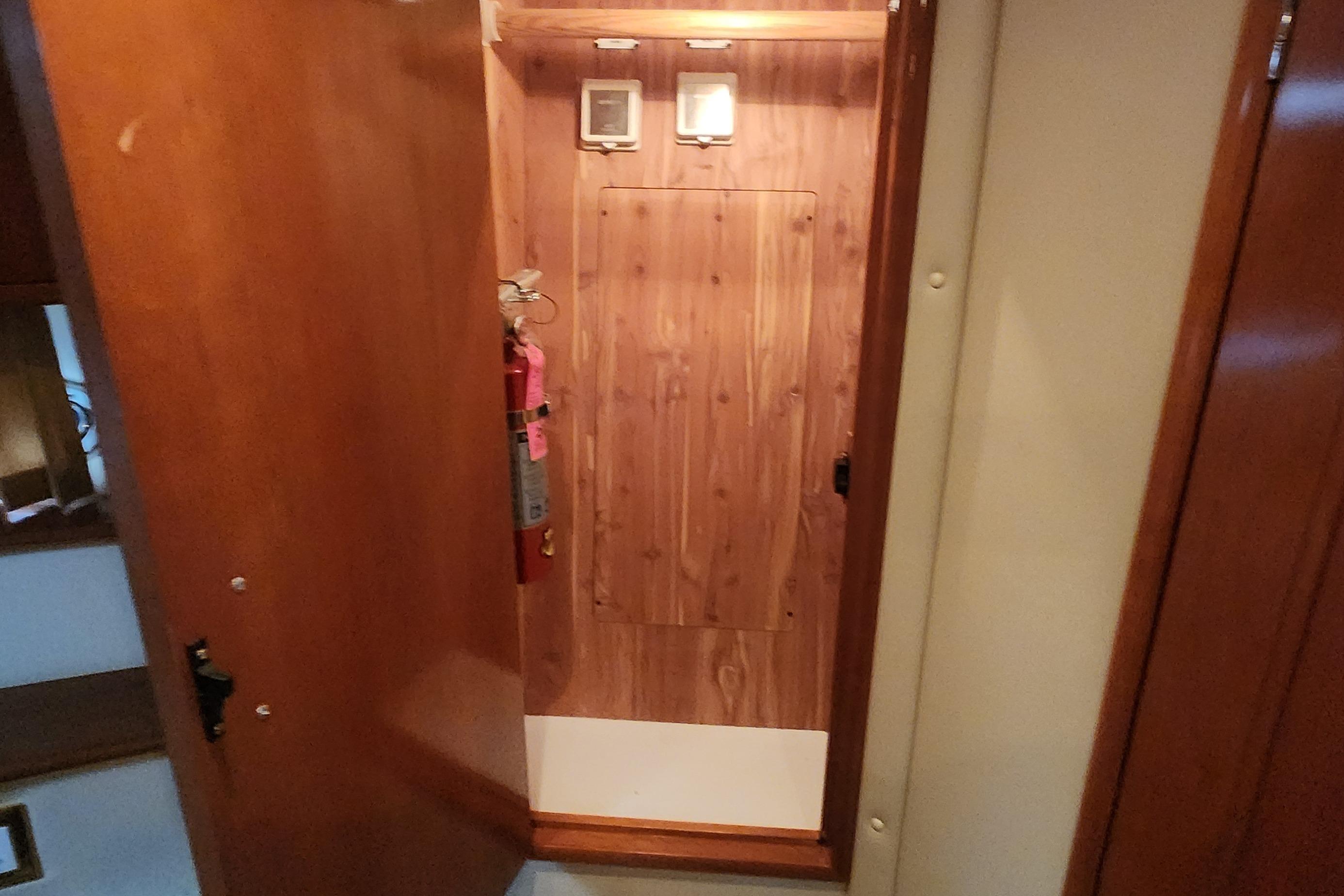 Interior of 2005 Carver 466 Motor Yacht with wooden paneling and fire extinguisher.