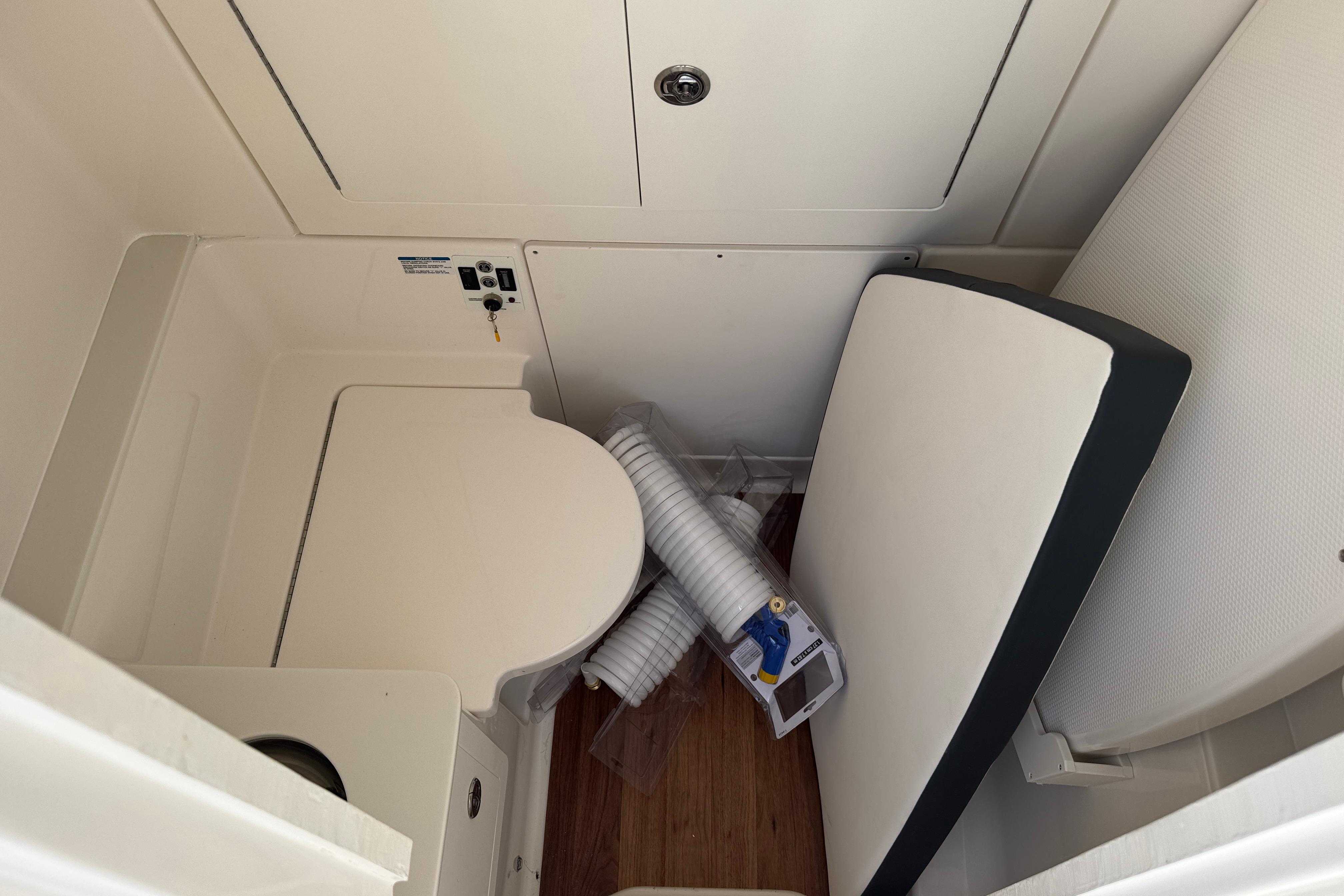 2025 Robalo R300 Center Console interior with compact toilet and storage space.