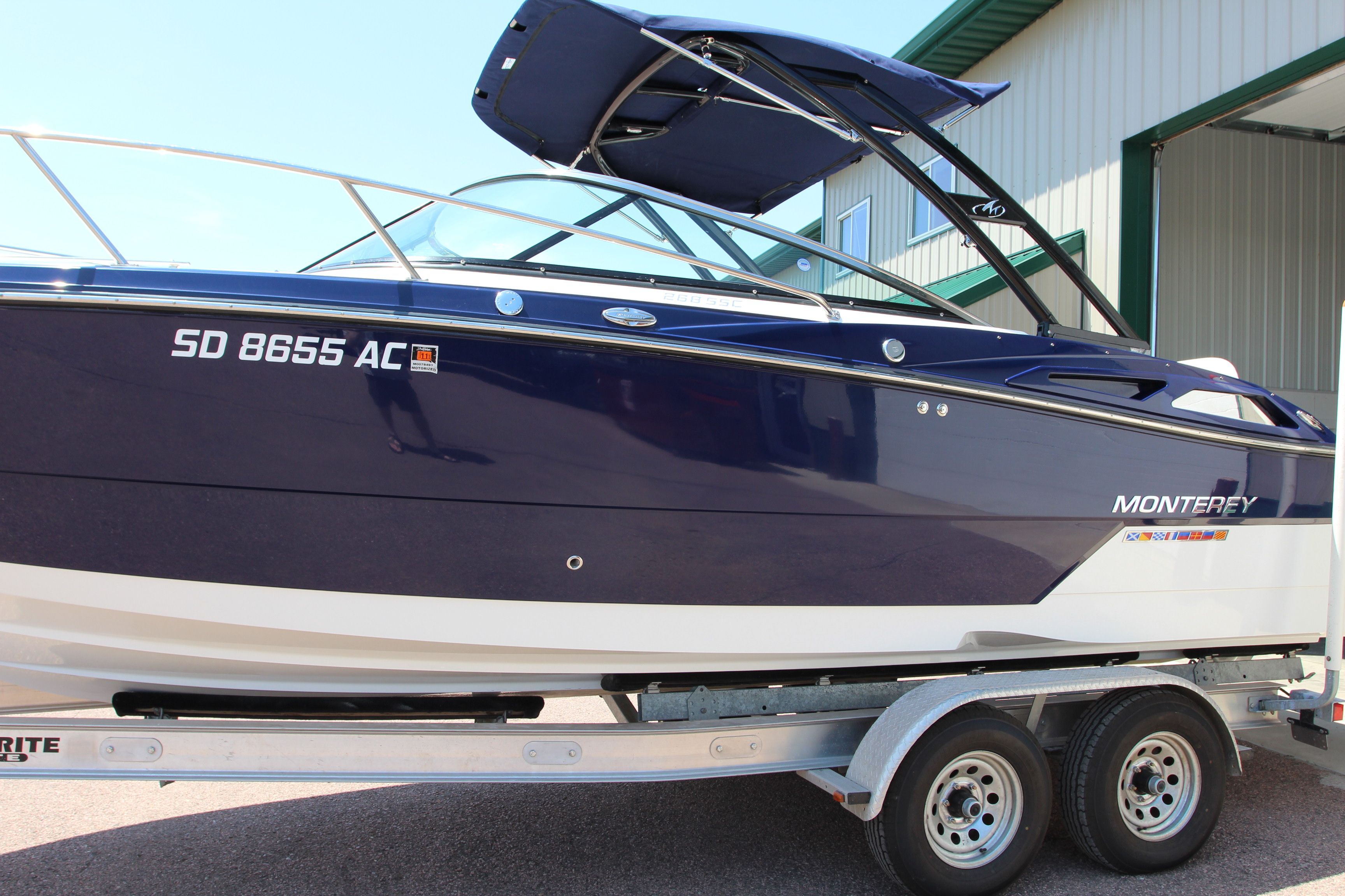 2015 Monterey 268SSC boat on trailer in front of building.