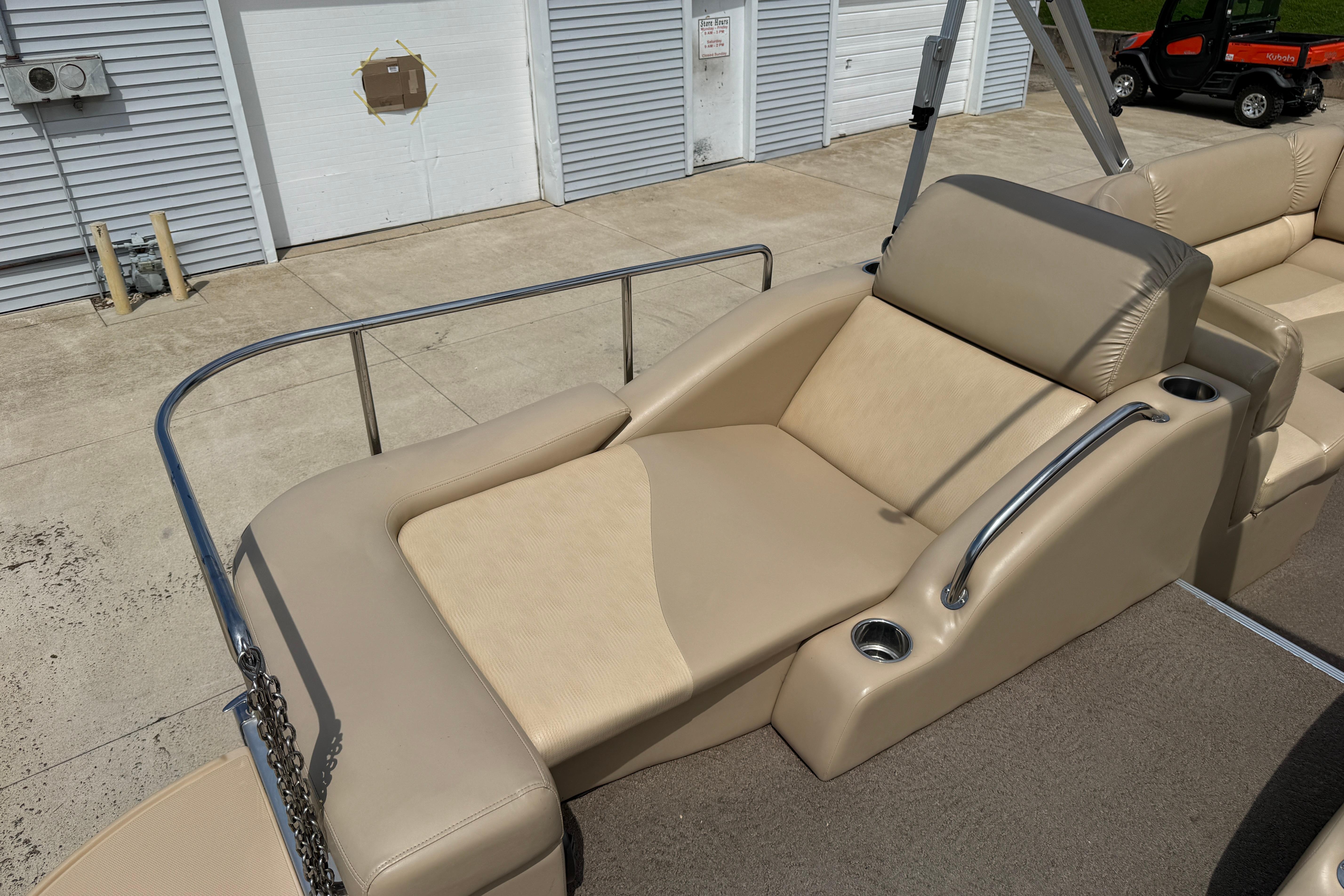 2011 Bennington 2575QCW I/O boat with beige lounge seating and cup holders.