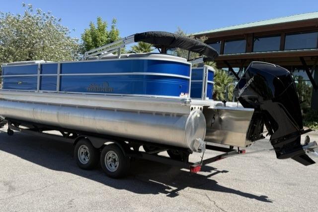 2026 Sun Tracker Party Barge 24 XP3 pontoon boat on trailer, parked outdoors.