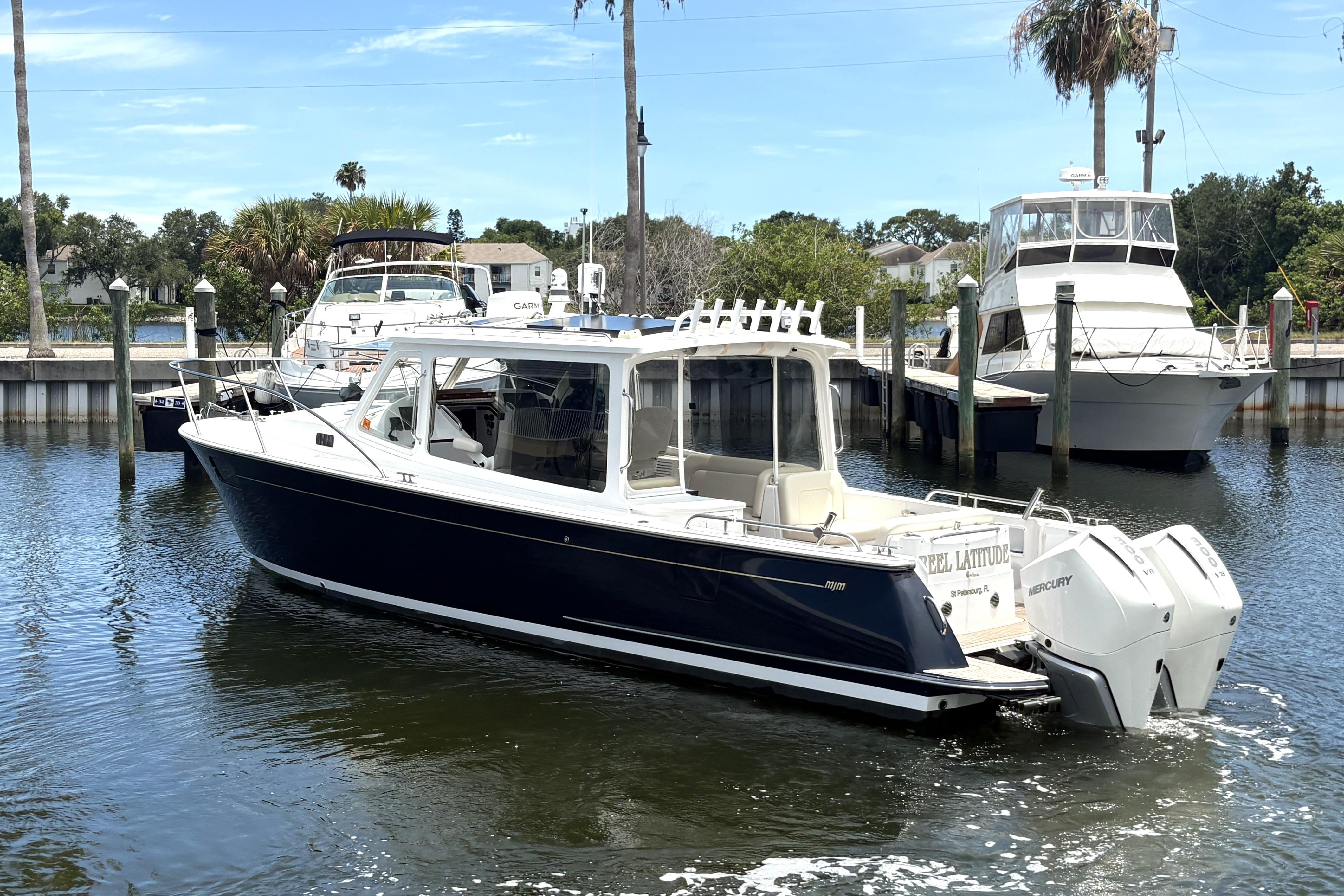 2024 MJM 35z boat docked in marina with clear blue sky.