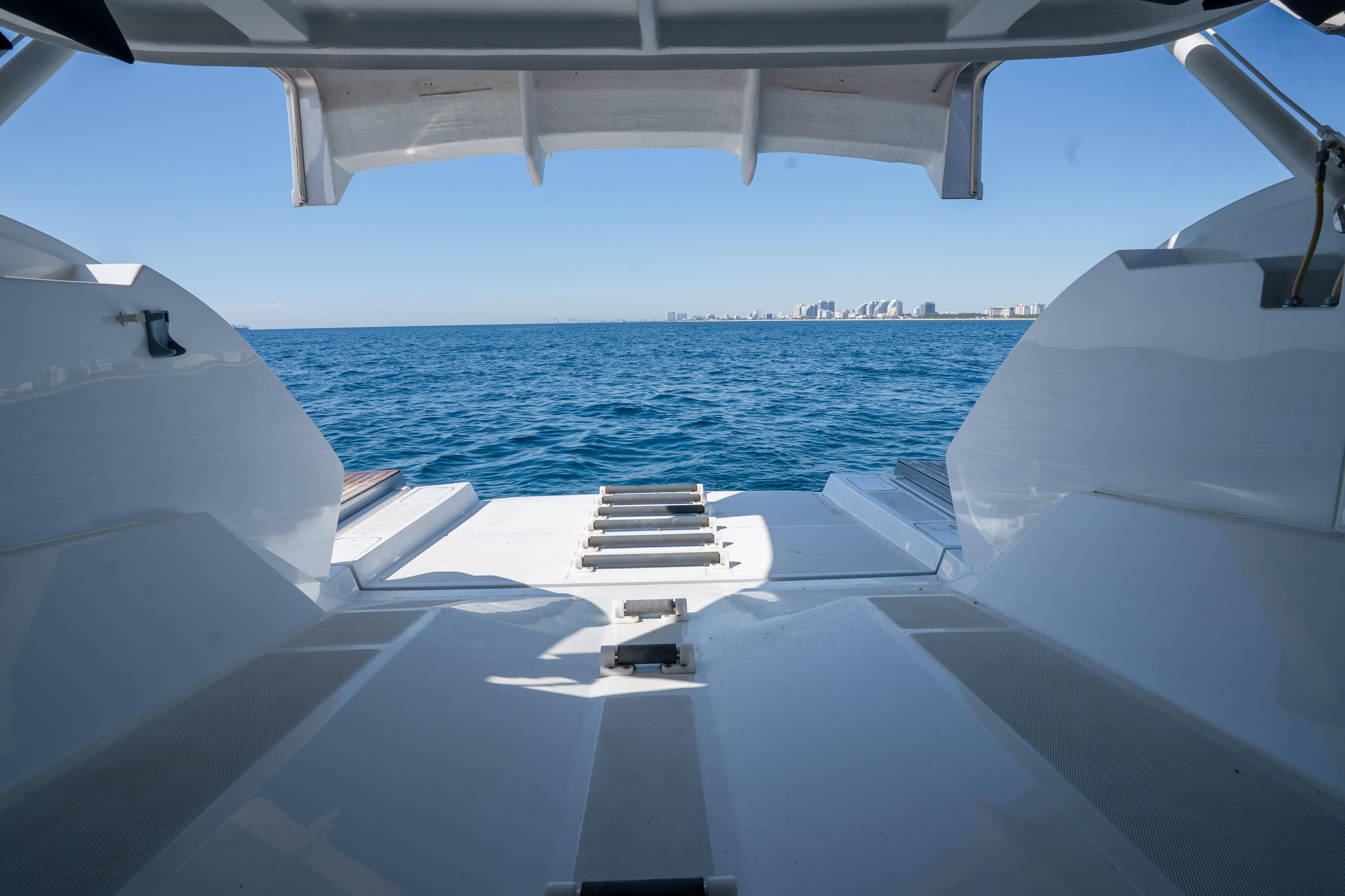 2024 Pershing 7X yacht deck overlooking ocean and distant city skyline.