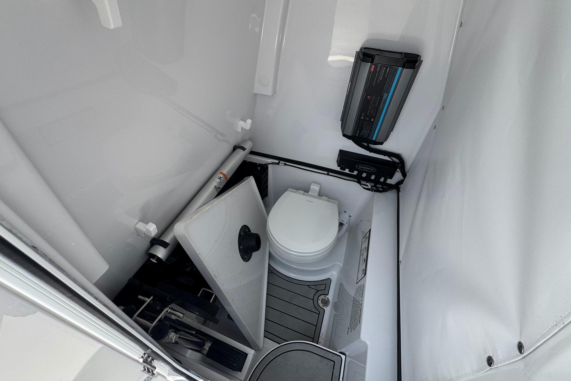 2026 Sportsman Open 262 Center Console boat interior with marine toilet and storage.
