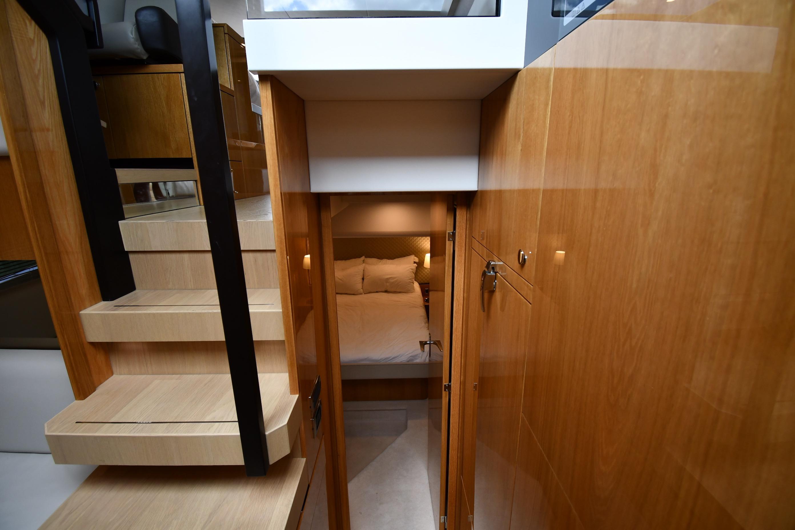 2024 Fairline G50 Targa yacht interior with wooden stairs and cozy bedroom.