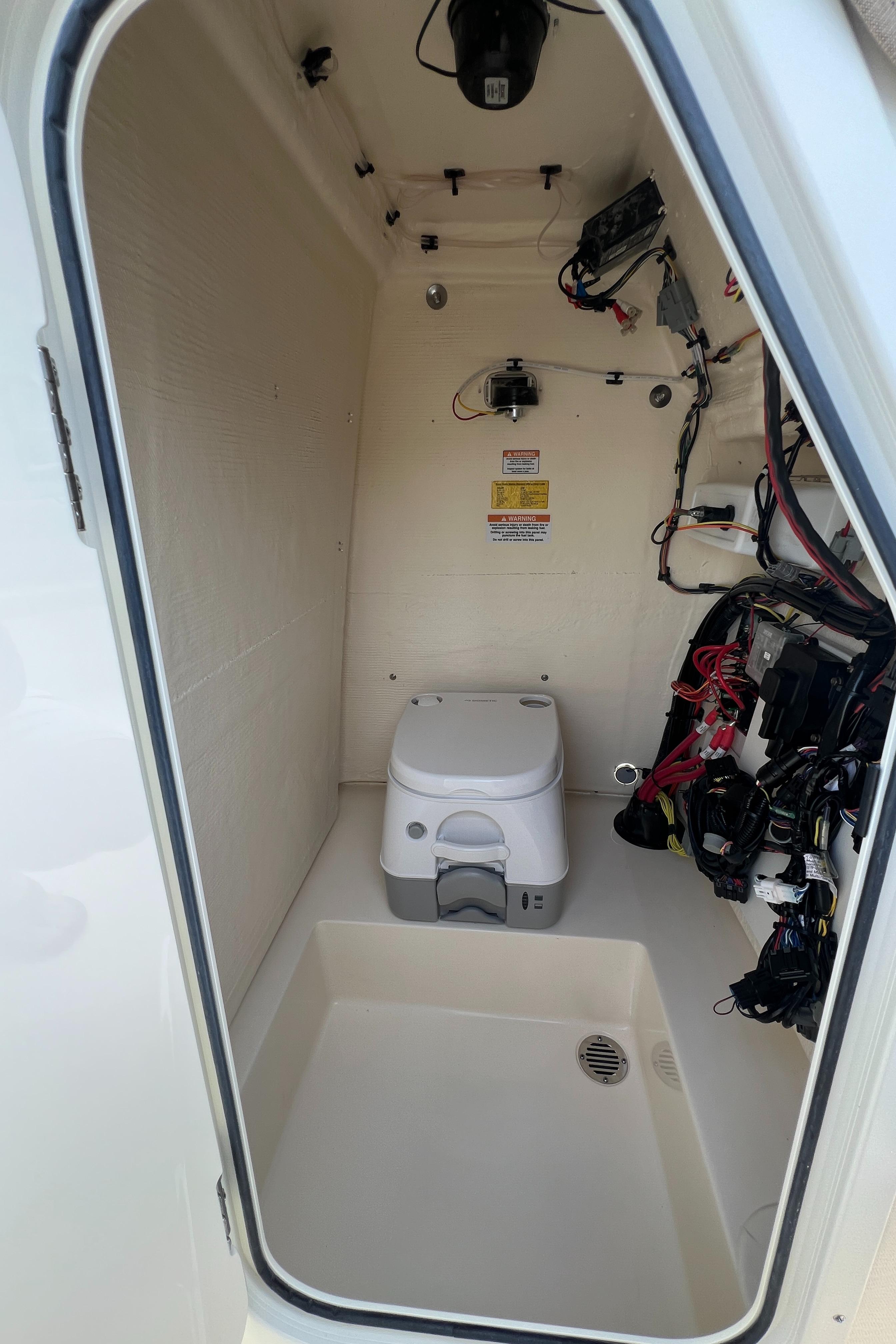 Interior of 2025 Scout 195 Sportfish boat with portable toilet and wiring.