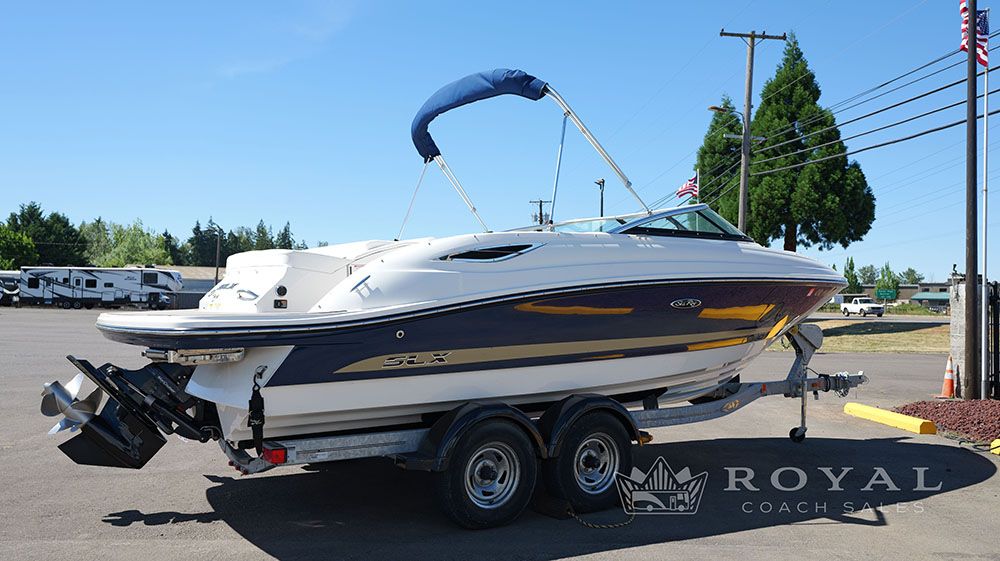 2014 Sea Ray SLX 230 on a trailer, with a blue canopy, in a parking lot.
