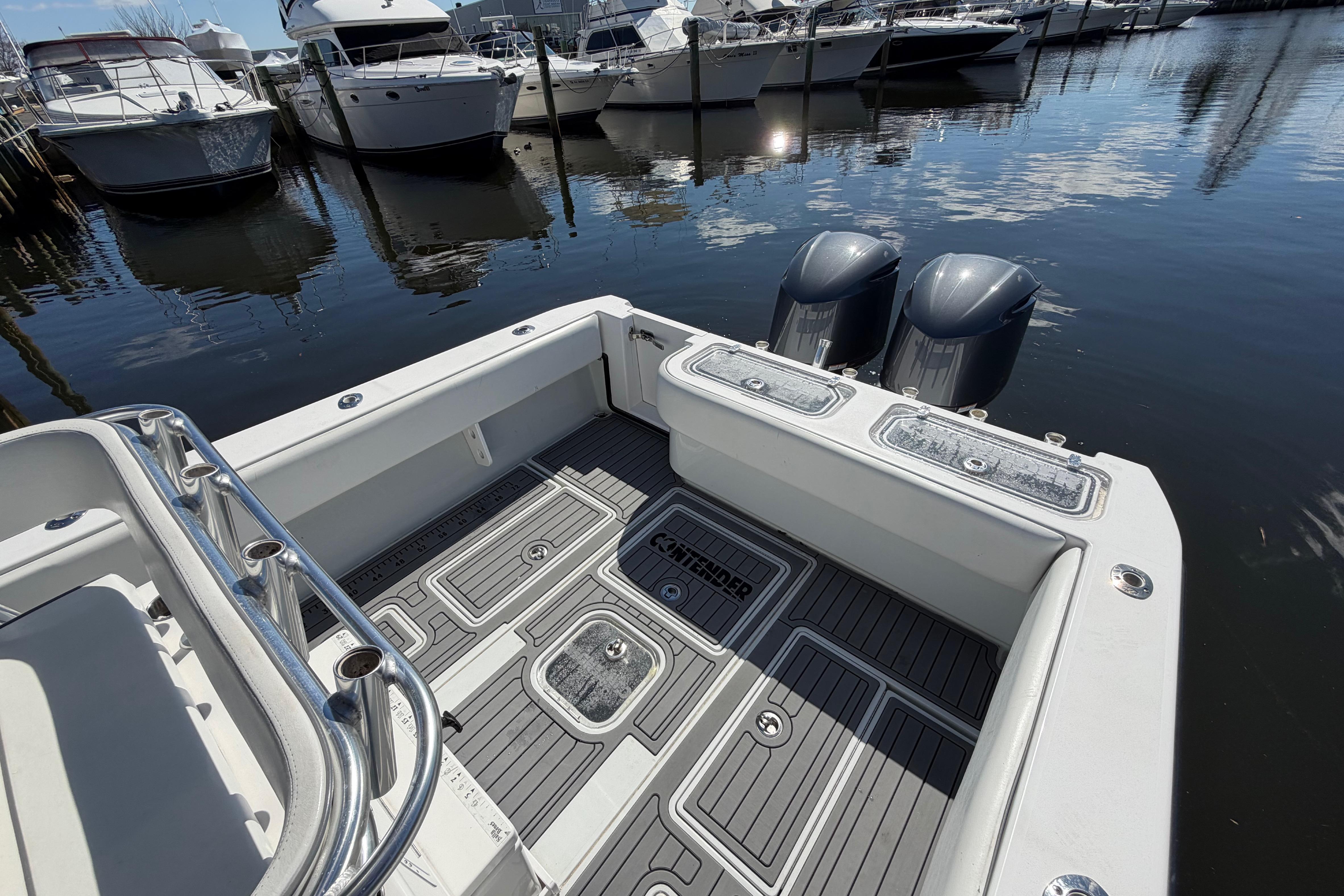 2015 Contender 32 ST boat with dual engines docked at marina.